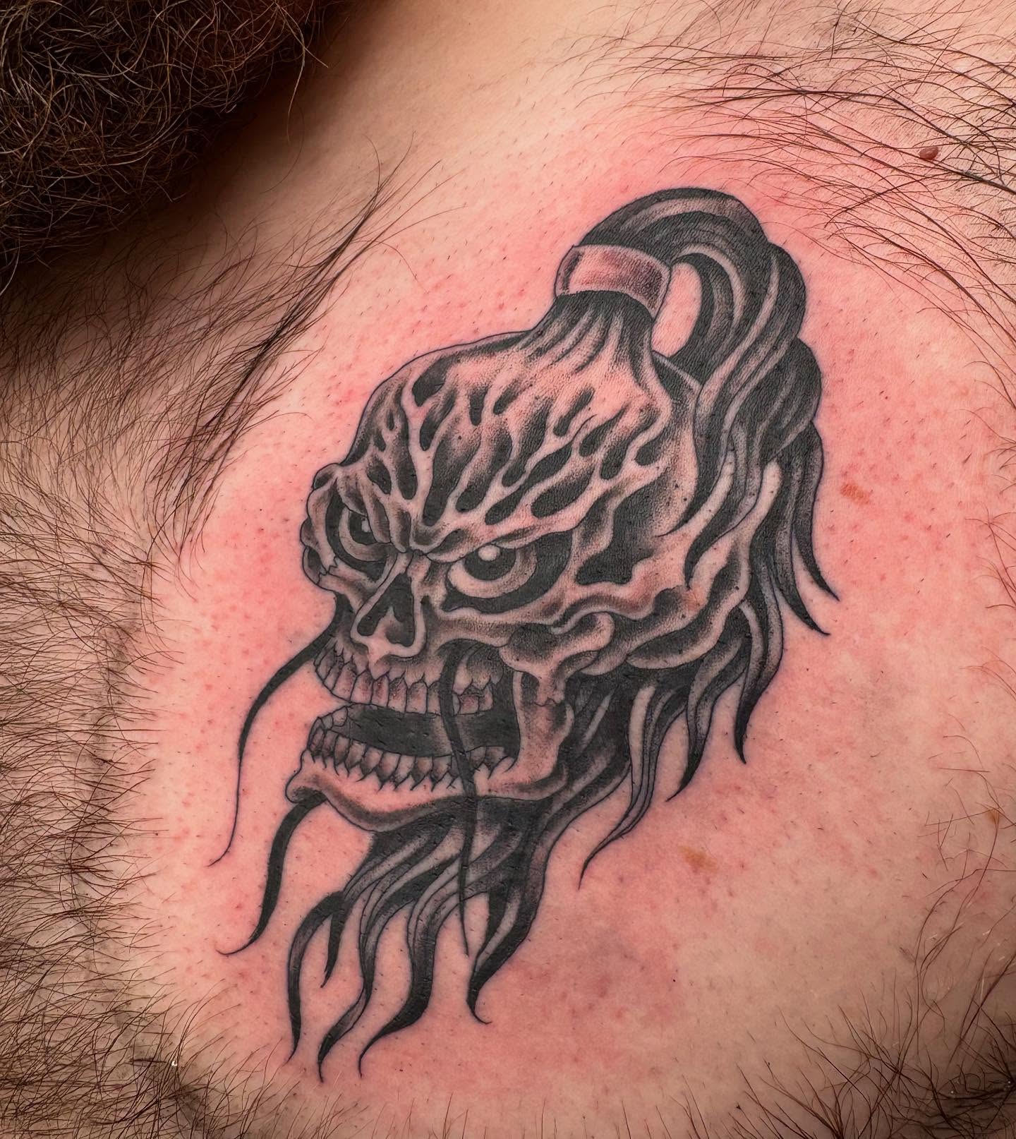 Skull black and grey tattoo on the chest by Zach Hendrickson