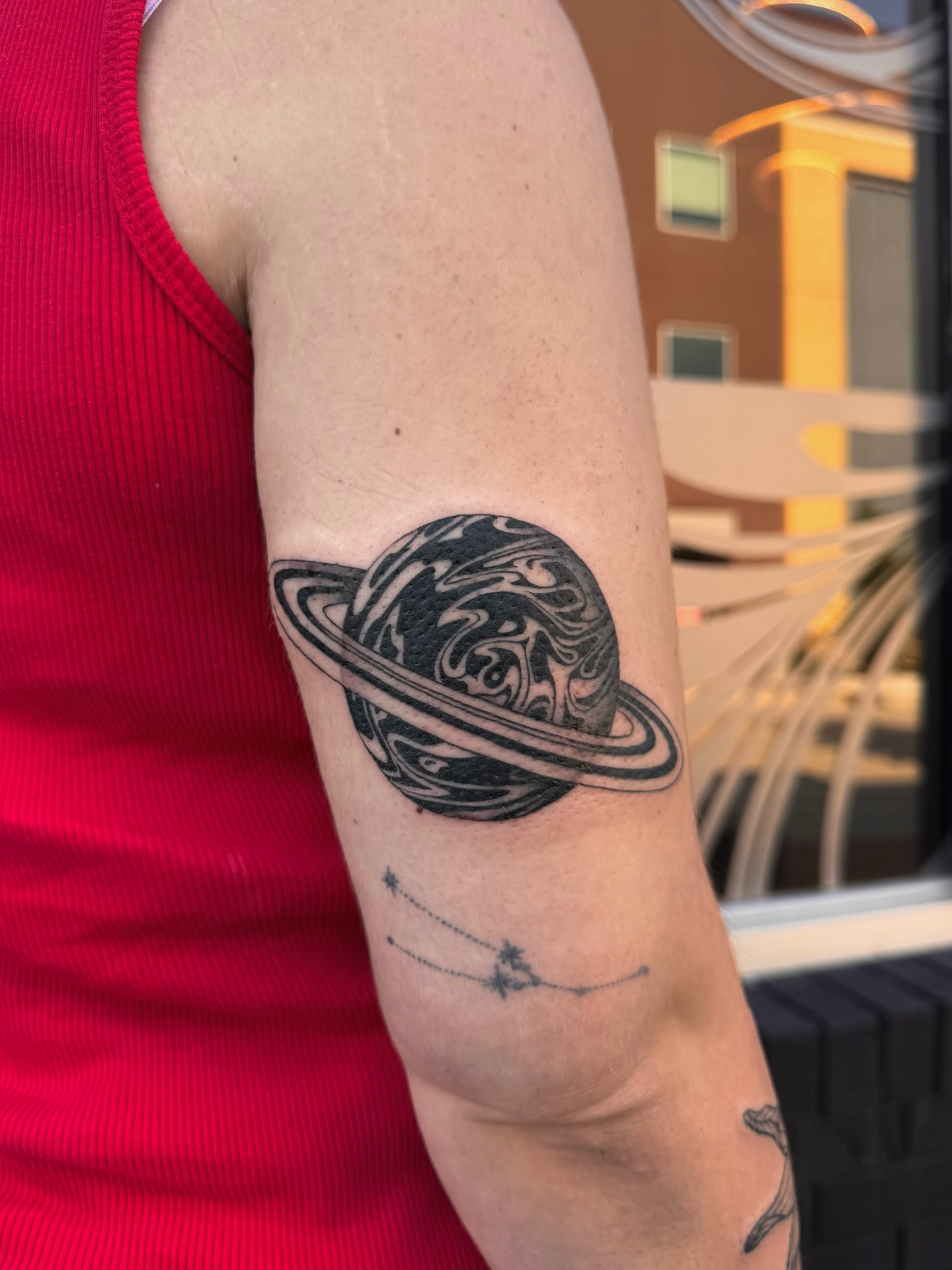 Saturn black and grey tattoo on the forearm by Suda