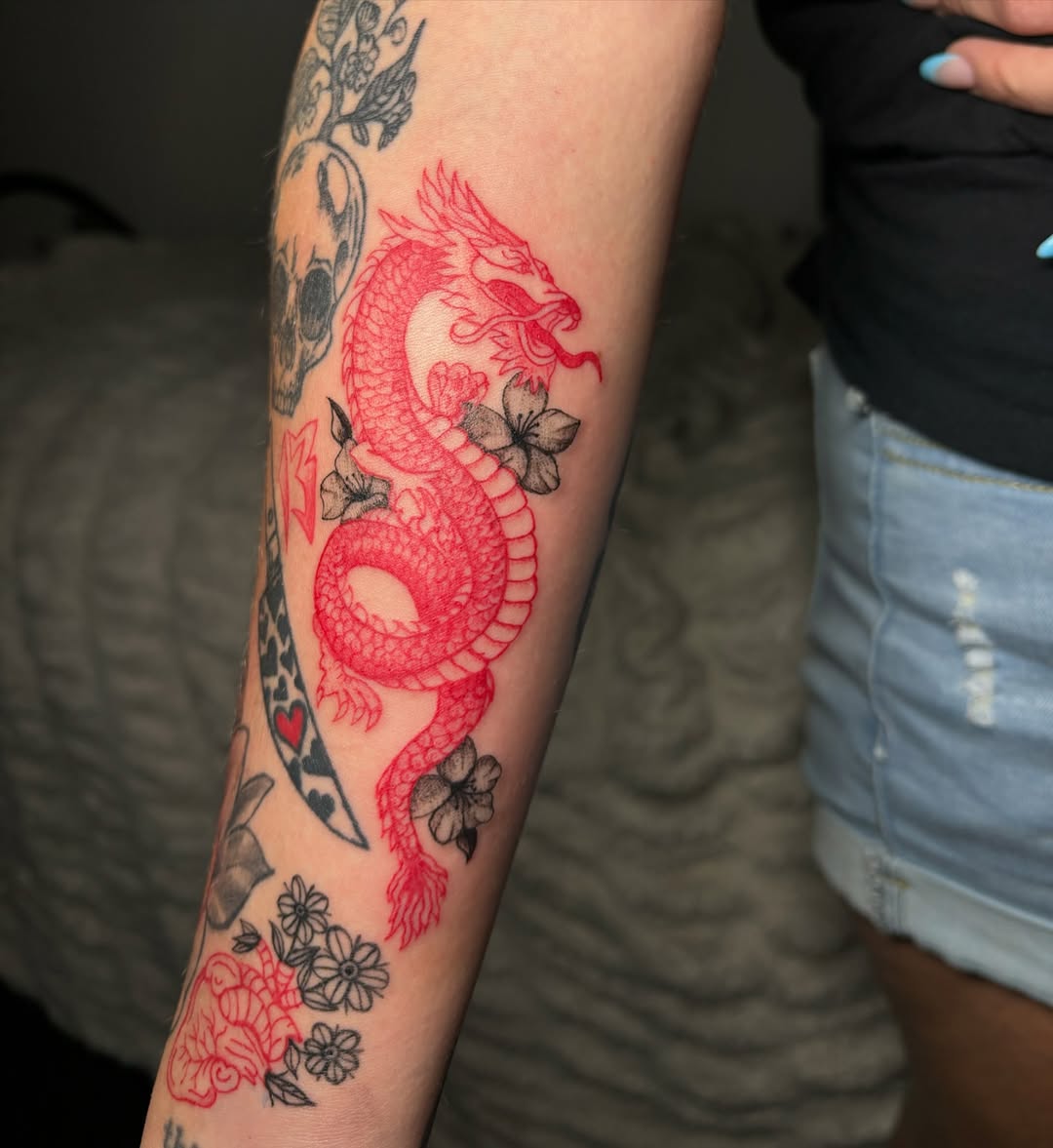 Red dragon with flowers American traditional tattoo on the forearm by Victoria