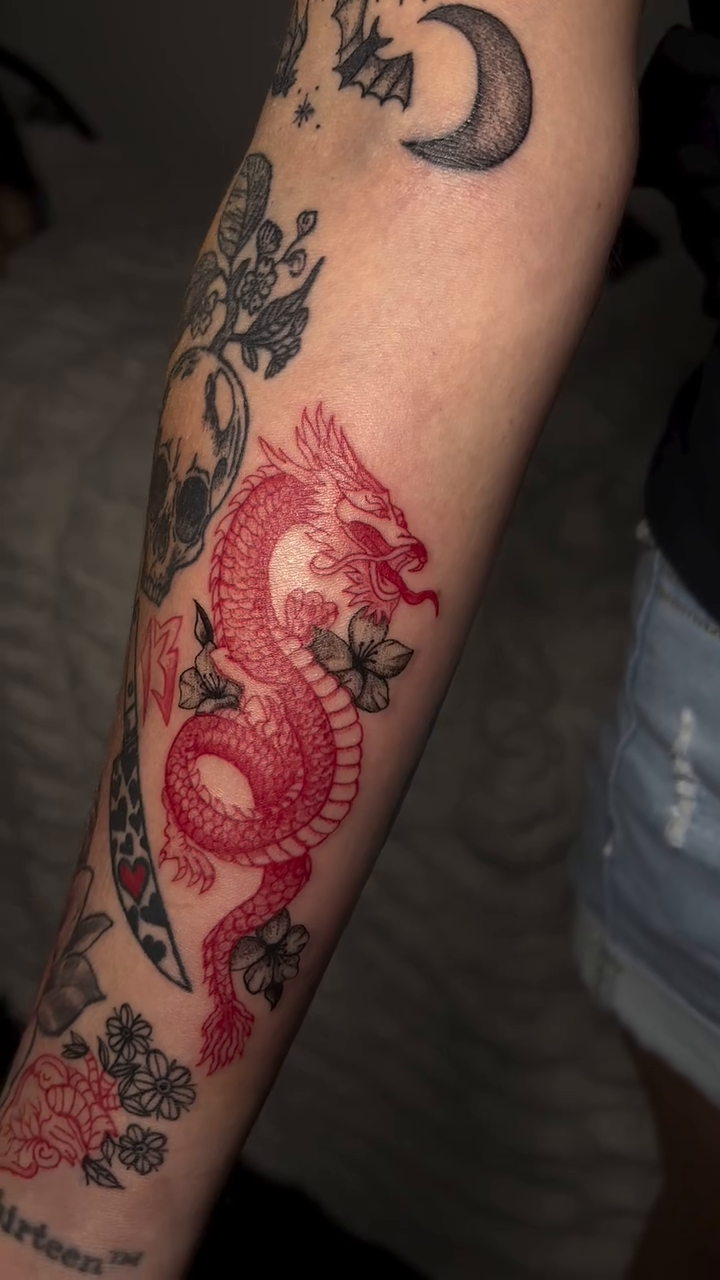Red dragon with flowers Japanese tattoo on the forearm by Victoria