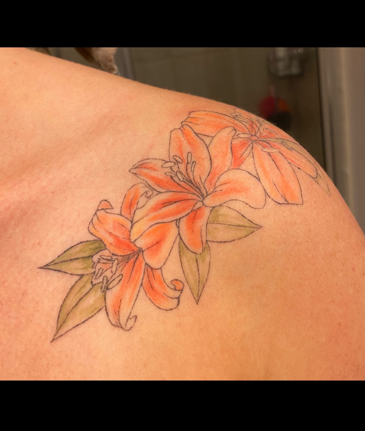 Lilies realism tattoo on the shoulder by Taylor Heidtbrink
