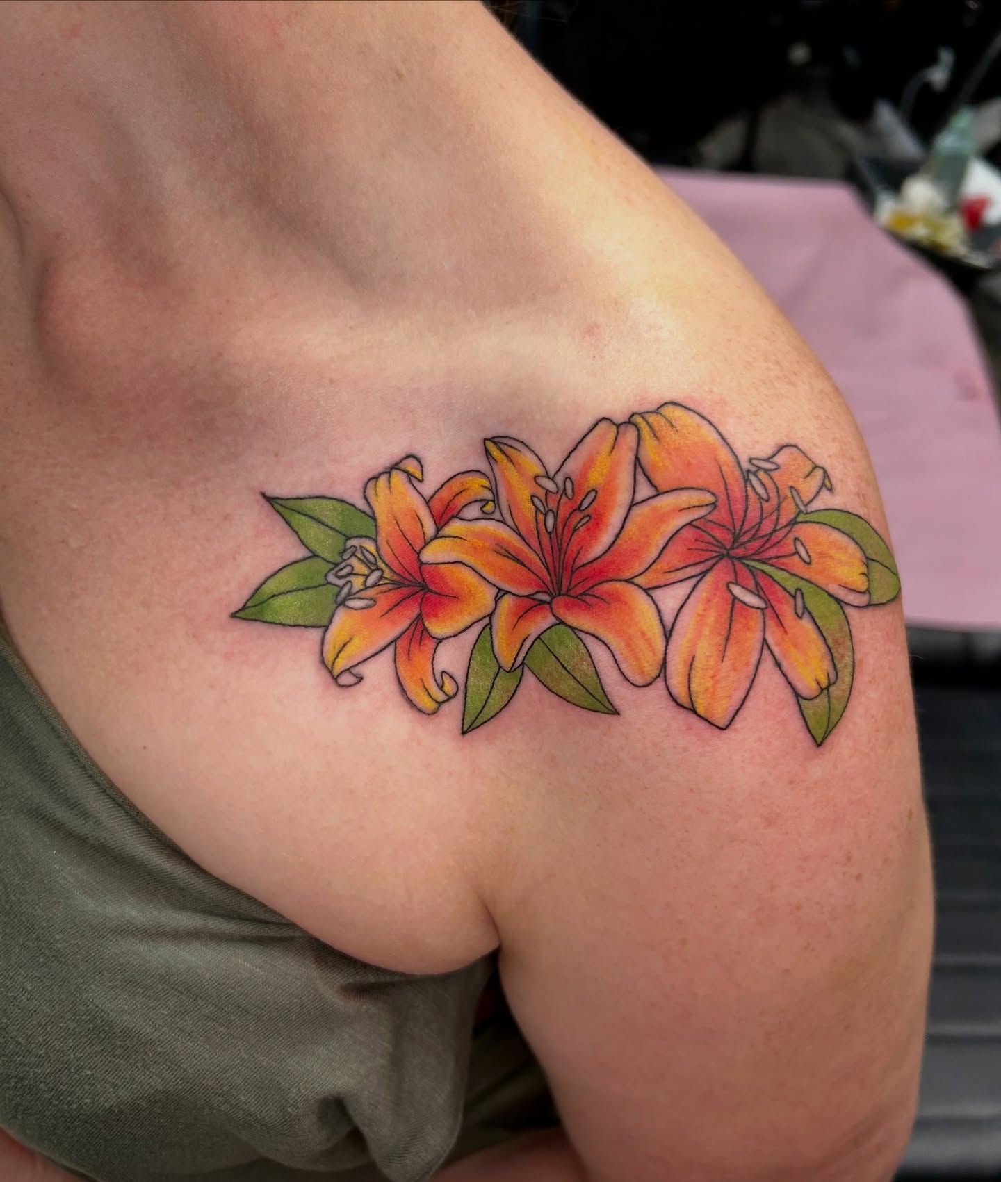Lilies realism tattoo on the shoulder by Taylor Heidtbrink