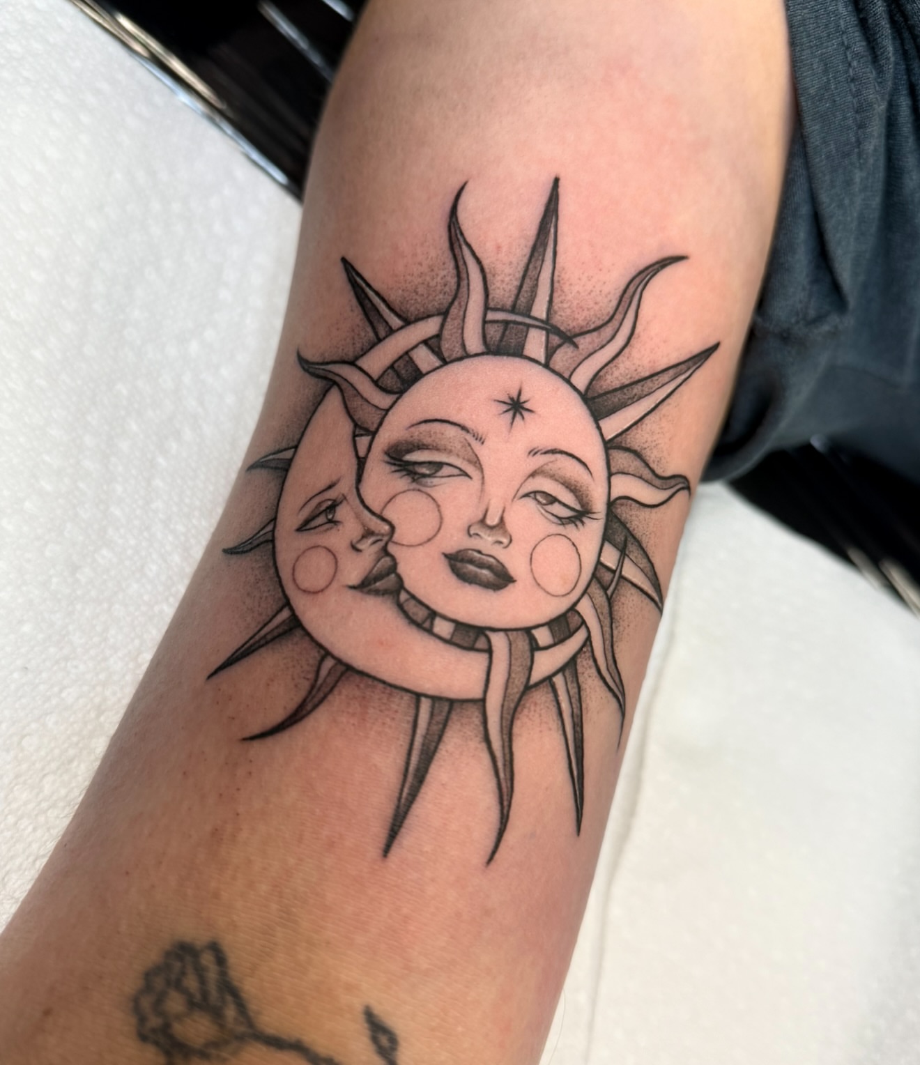 Sun and moon faces dotwork tattoo on the forearm by dinah