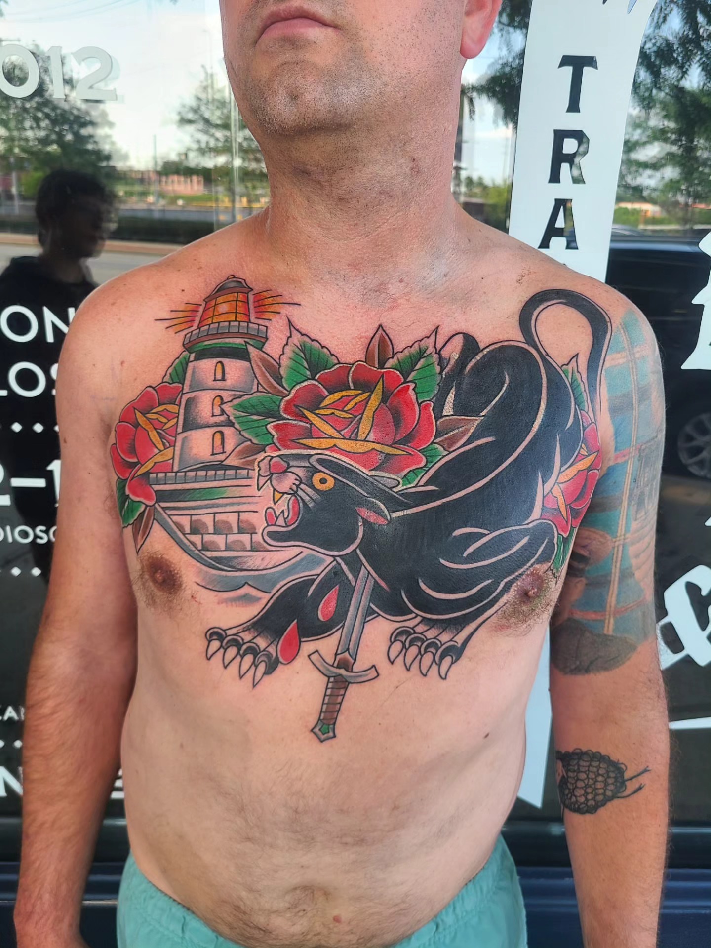 Panther and lighthouse American traditional tattoo on the chest by David Vodicka