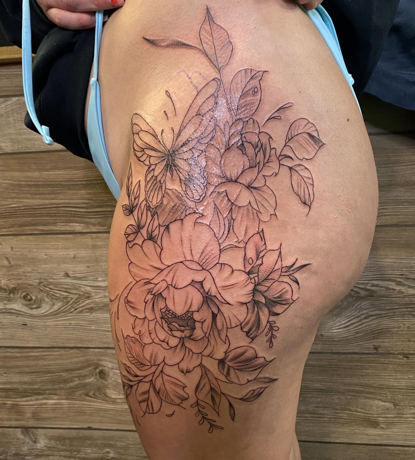 Peony bouquet realism tattoo on the thigh by Spencer Jones Tattoos