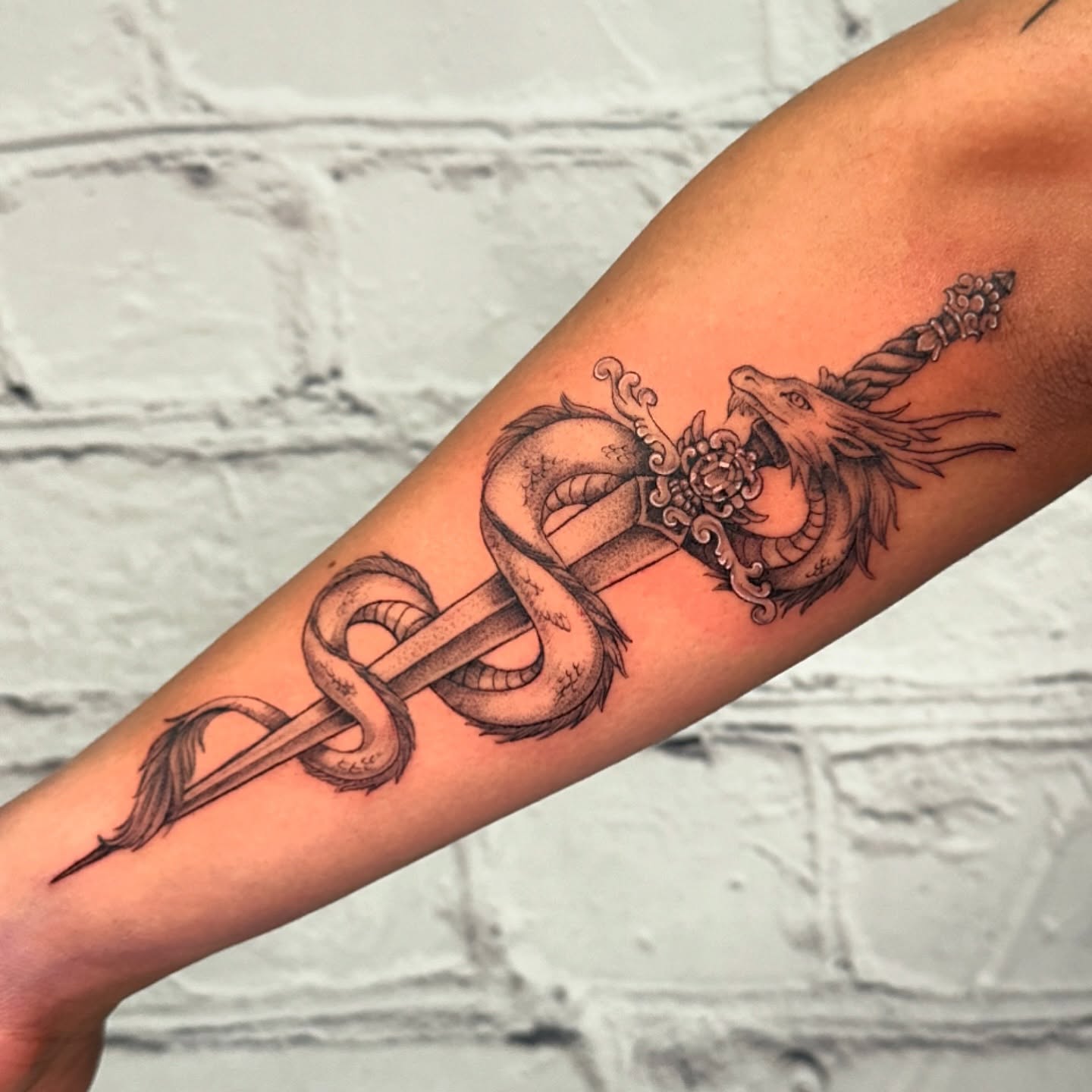 Dragon and sword black and grey tattoo on the forearm by Stephen Hansen