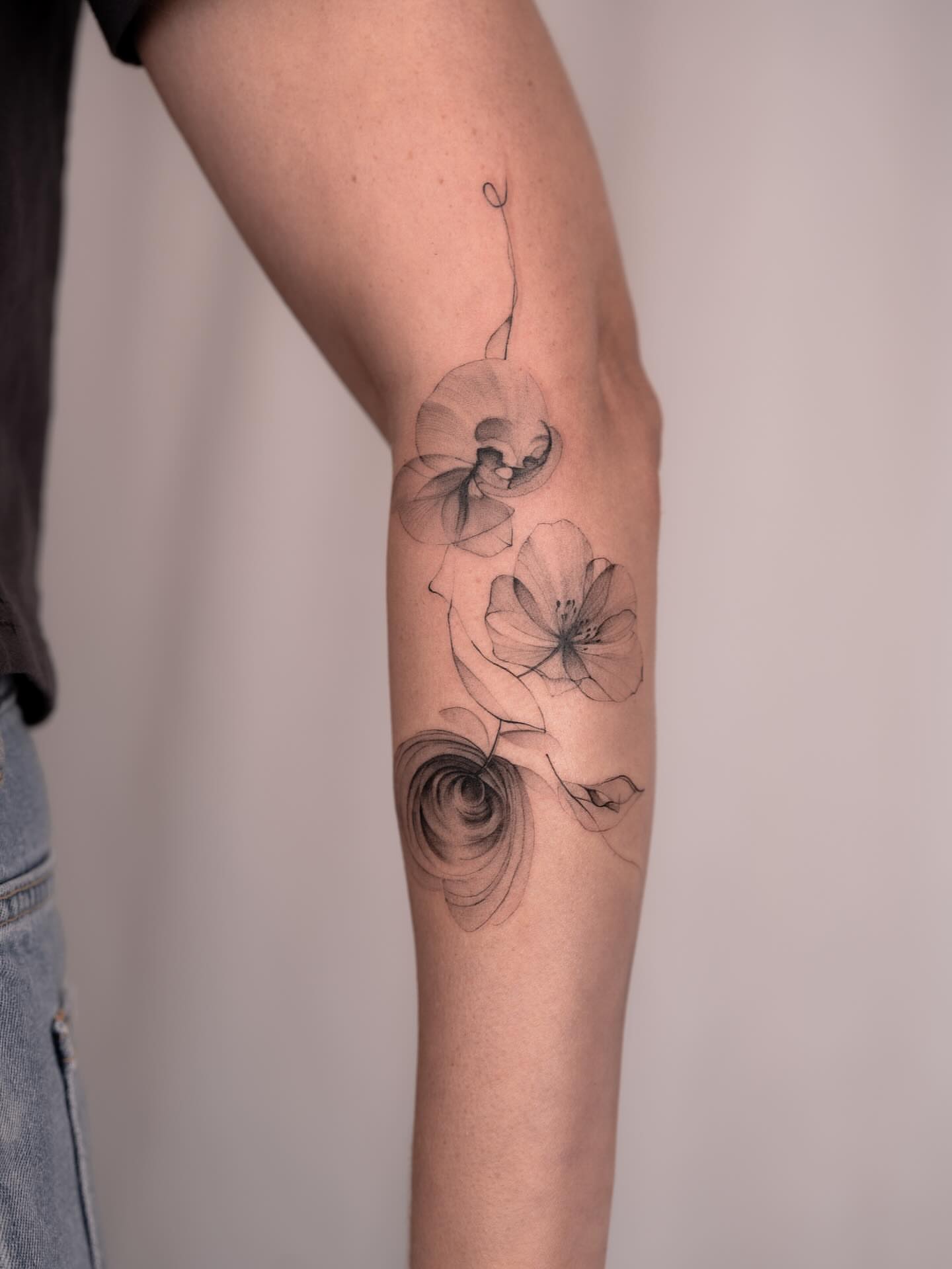 Flowers black and grey tattoo on the forearm by Leo Gao