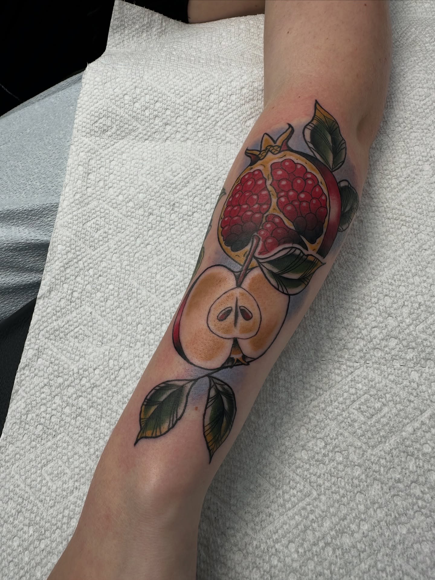 Pomegranate and apples American traditional tattoo on the forearm by Heather Cherish