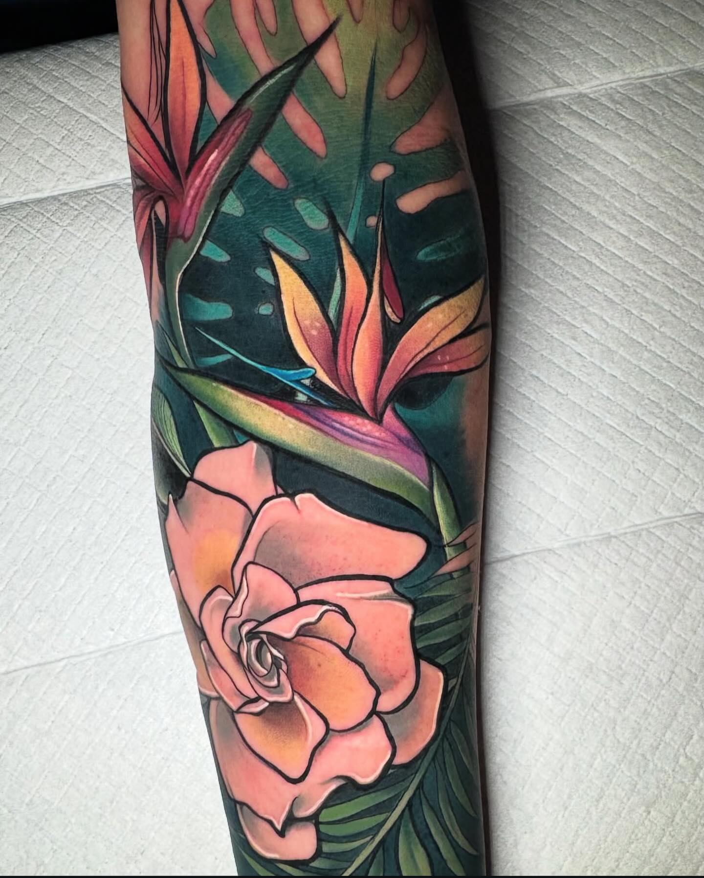 Bird of paradise and rose American traditional tattoo on the forearm by Caitlyn