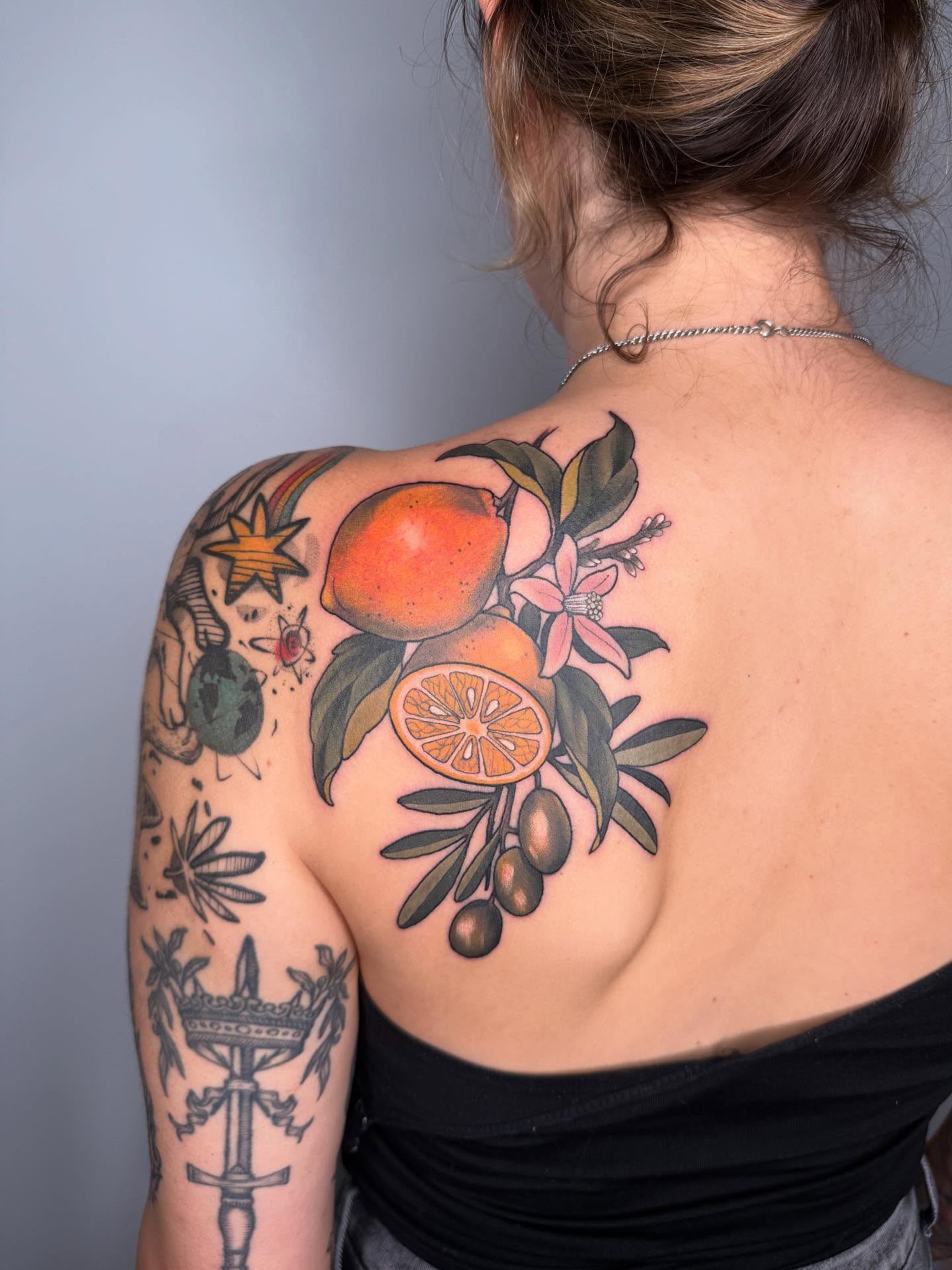 Citrus fruits and flowers realism tattoo on the shoulder by Samantha Compasso Ford