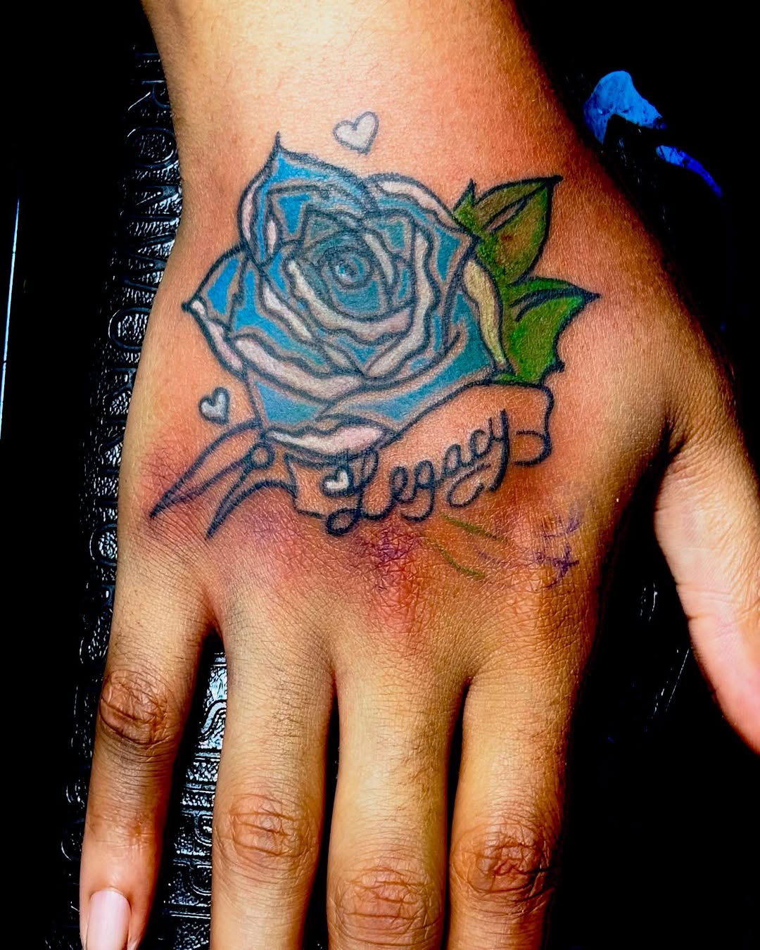 Blue rose with legacy text tattoo on the hand by Family and Loyalty