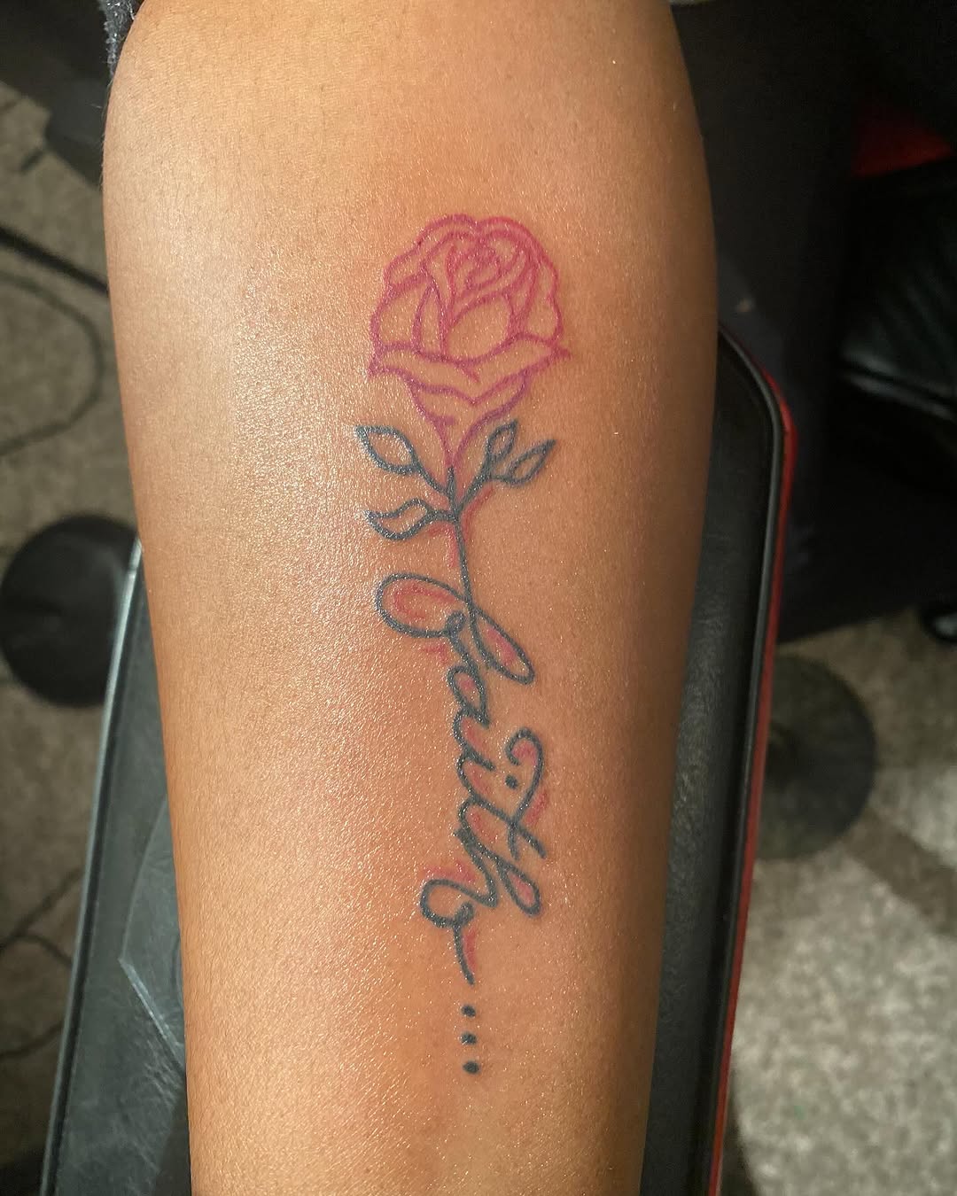 Rose and script lettering lettering tattoo on the forearm by Family and Loyalty