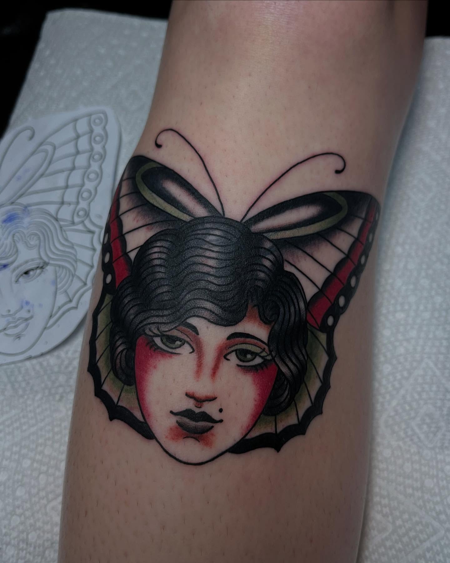 Woman's face with butterfly wings American traditional tattoo on the forearm by Kayla Faircloth, Charlotte, North Carolina