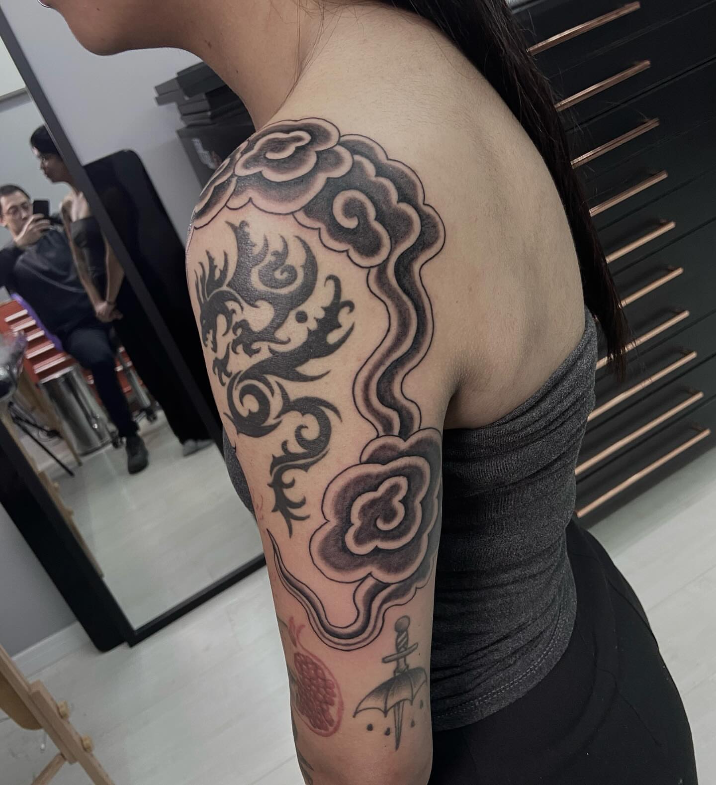 Dragon and cloud black and grey tattoo on the upper arm by Lucas Naganuma