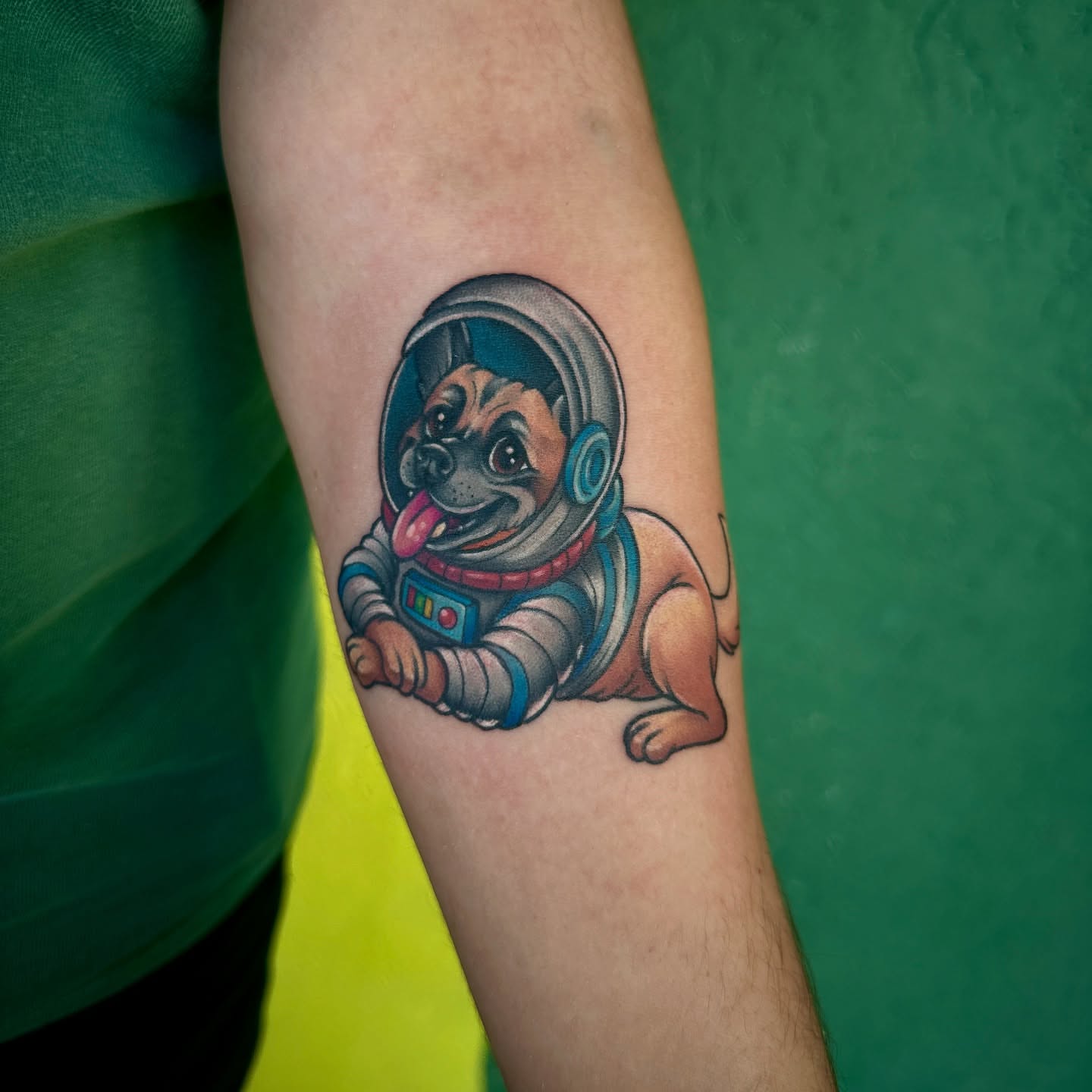 Dog astronaut illustrative tattoo on the forearm by Holle Hellfire