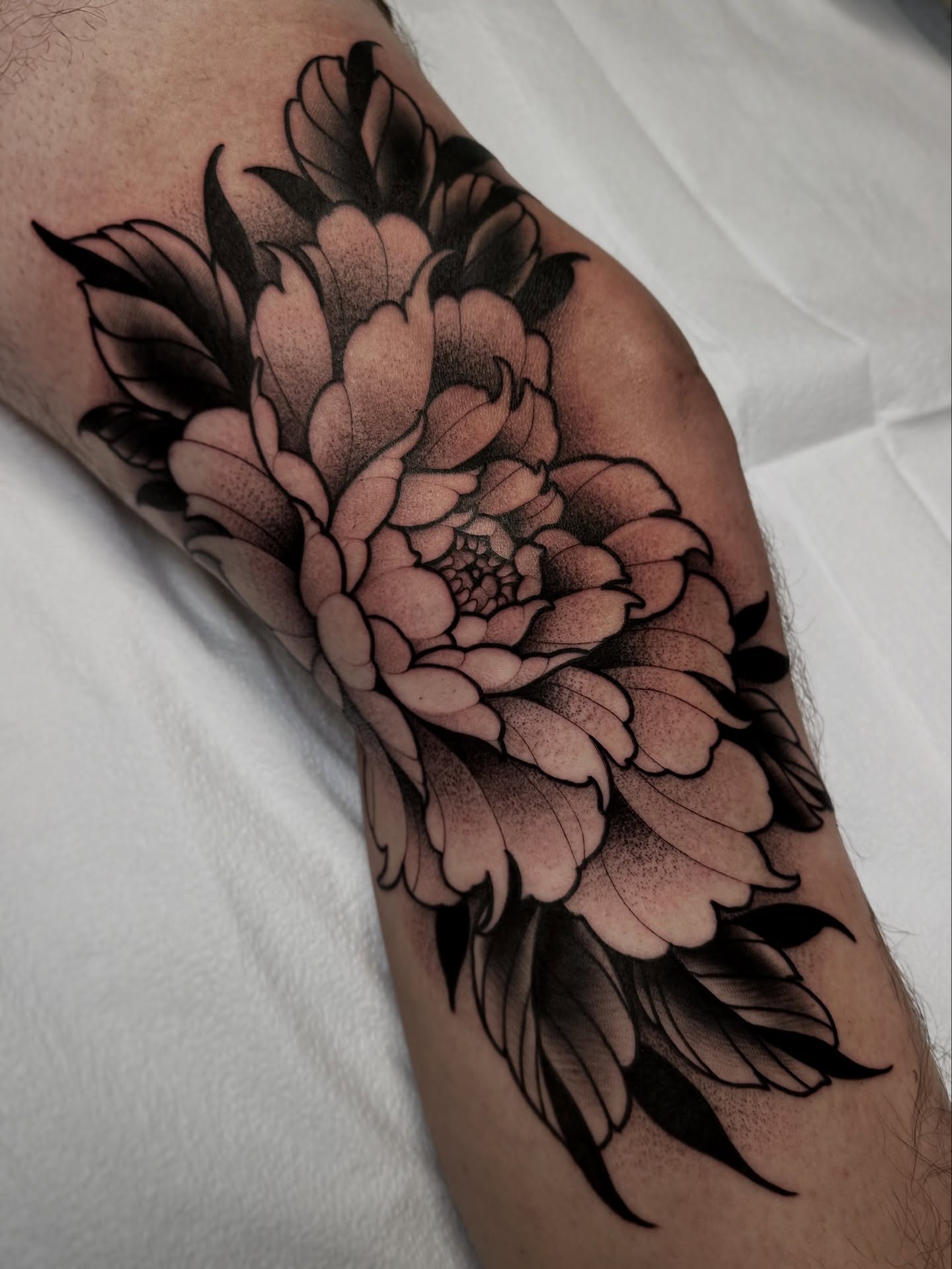 Flower black and grey tattoo on the forearm by Patrick Whiting