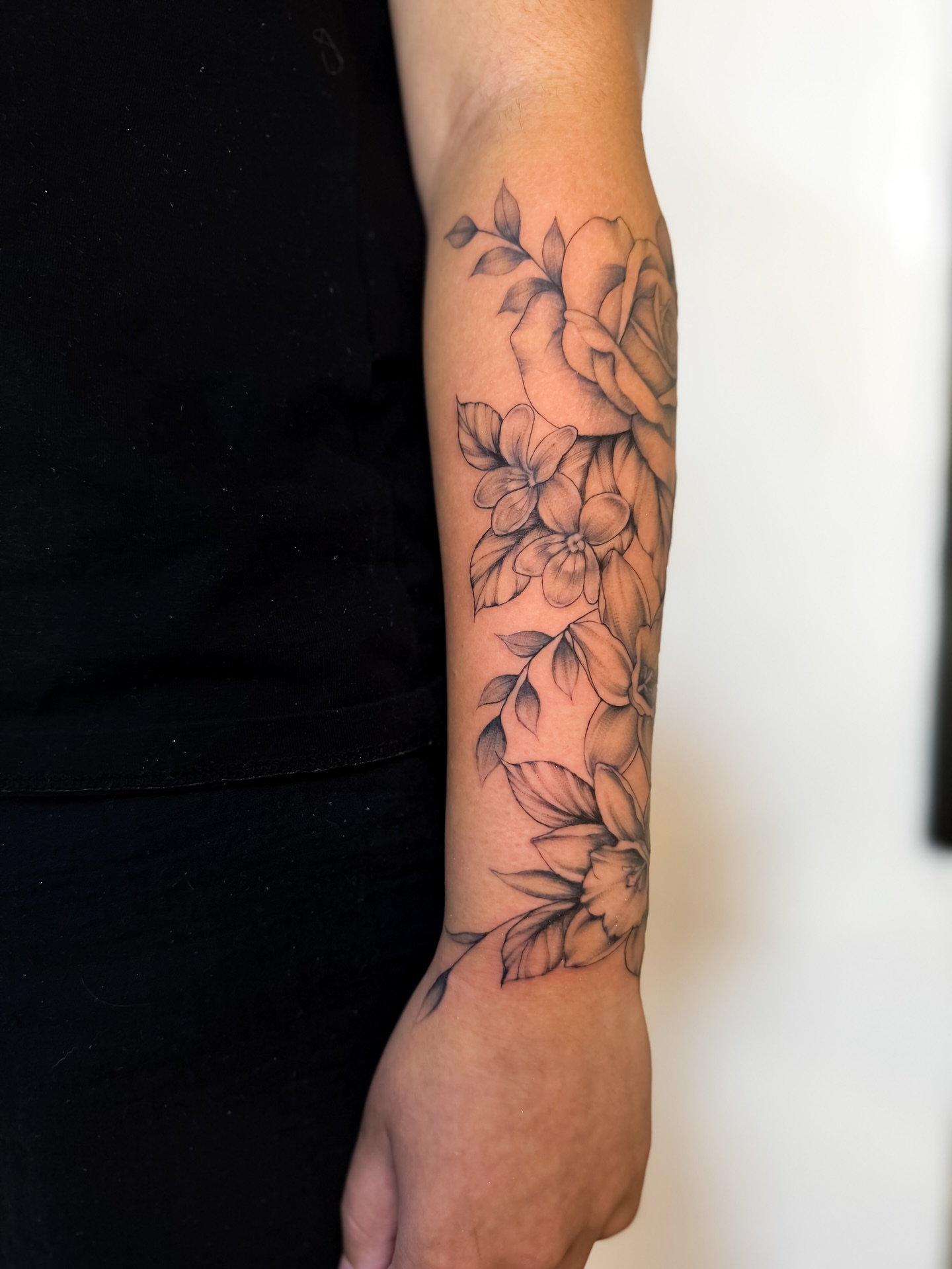 Floral bouquet black and grey tattoo on the forearm by Amelia