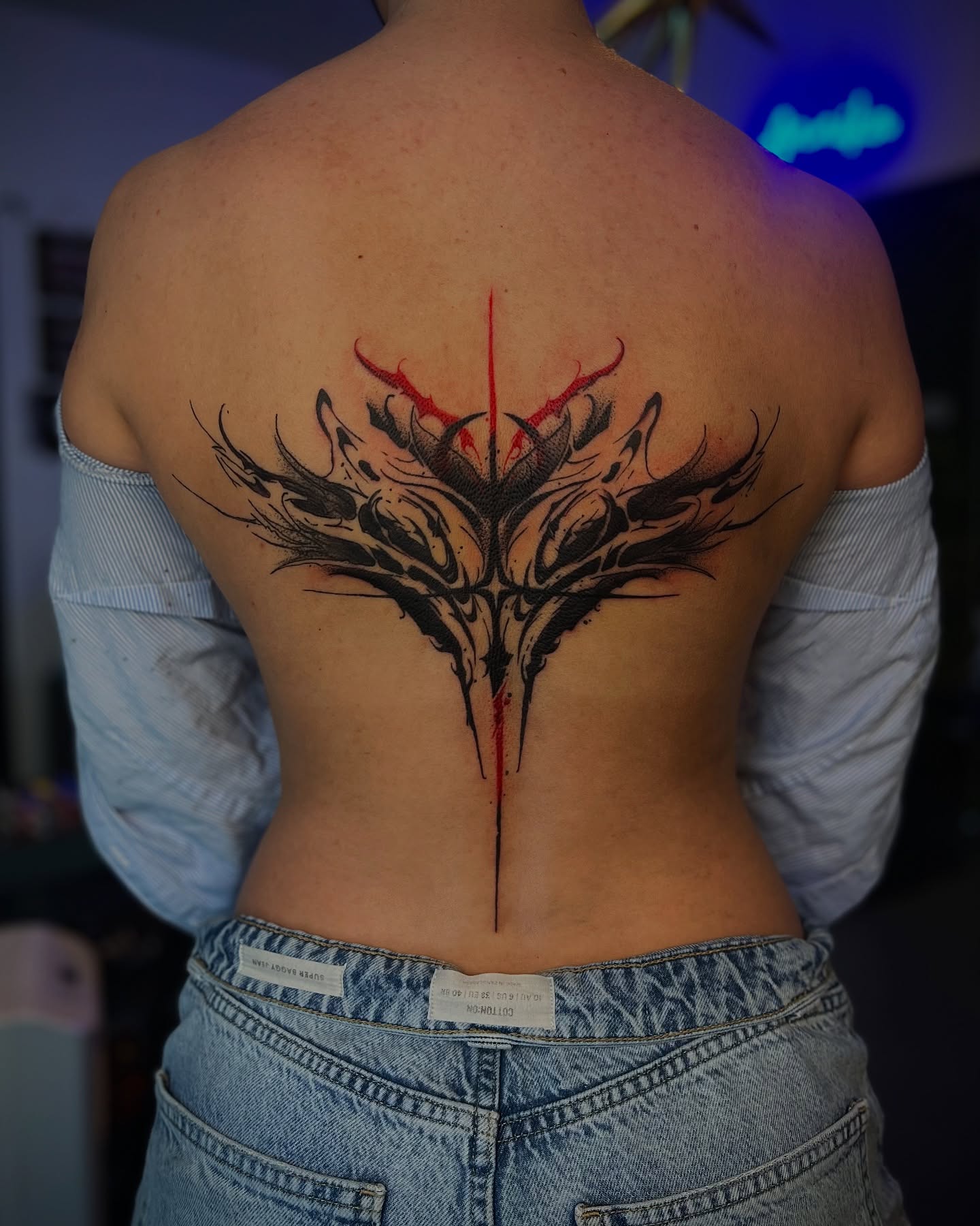Abstract floral tribal tattoo on the back by Nikki Ward