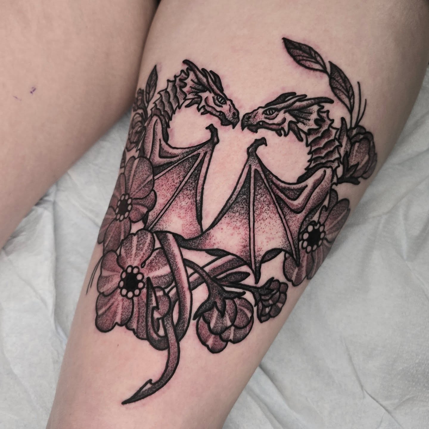 Dragons and flowers dotwork tattoo on the thigh by Adison Essig