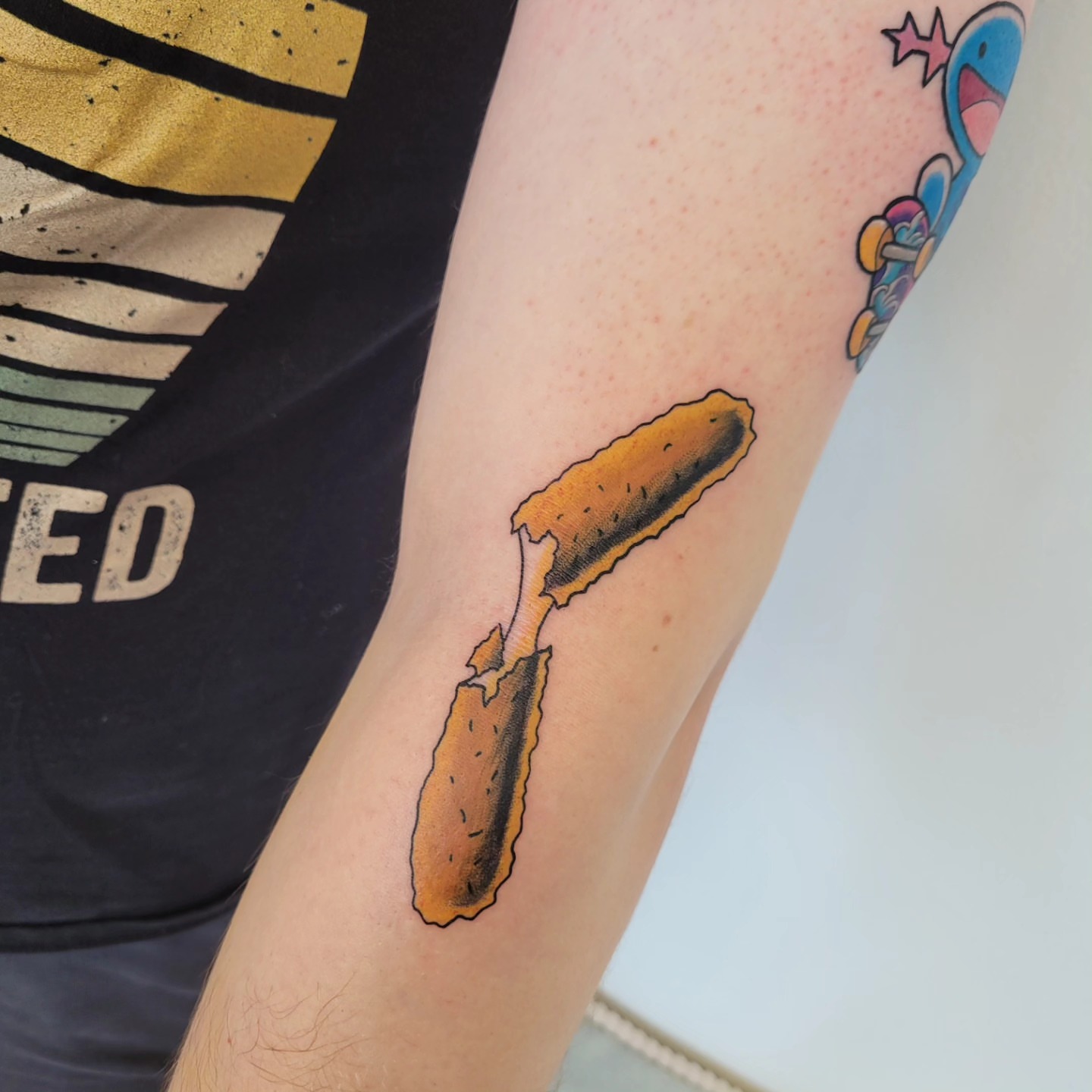 Corn dog realism tattoo on the forearm by Wray Saulsberry