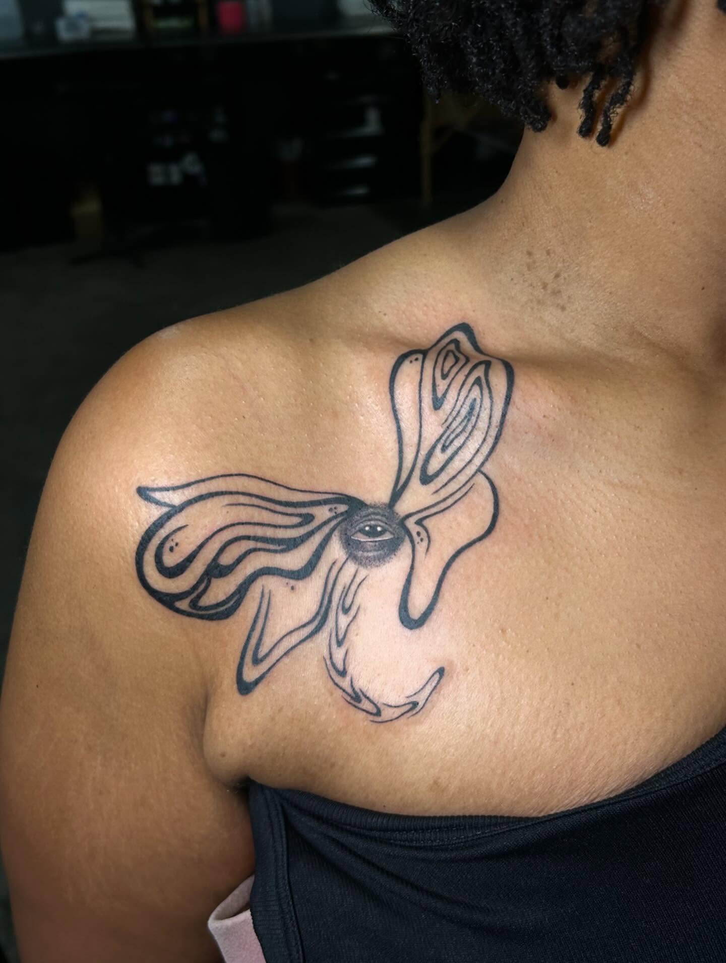 Eye with flowing petals surrealism tattoo on the chest by Kerri Colello Sittenauer
