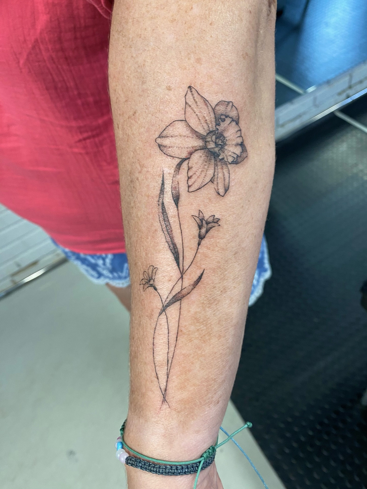 Daffodil black and grey tattoo on the forearm by Ellena Reggiani