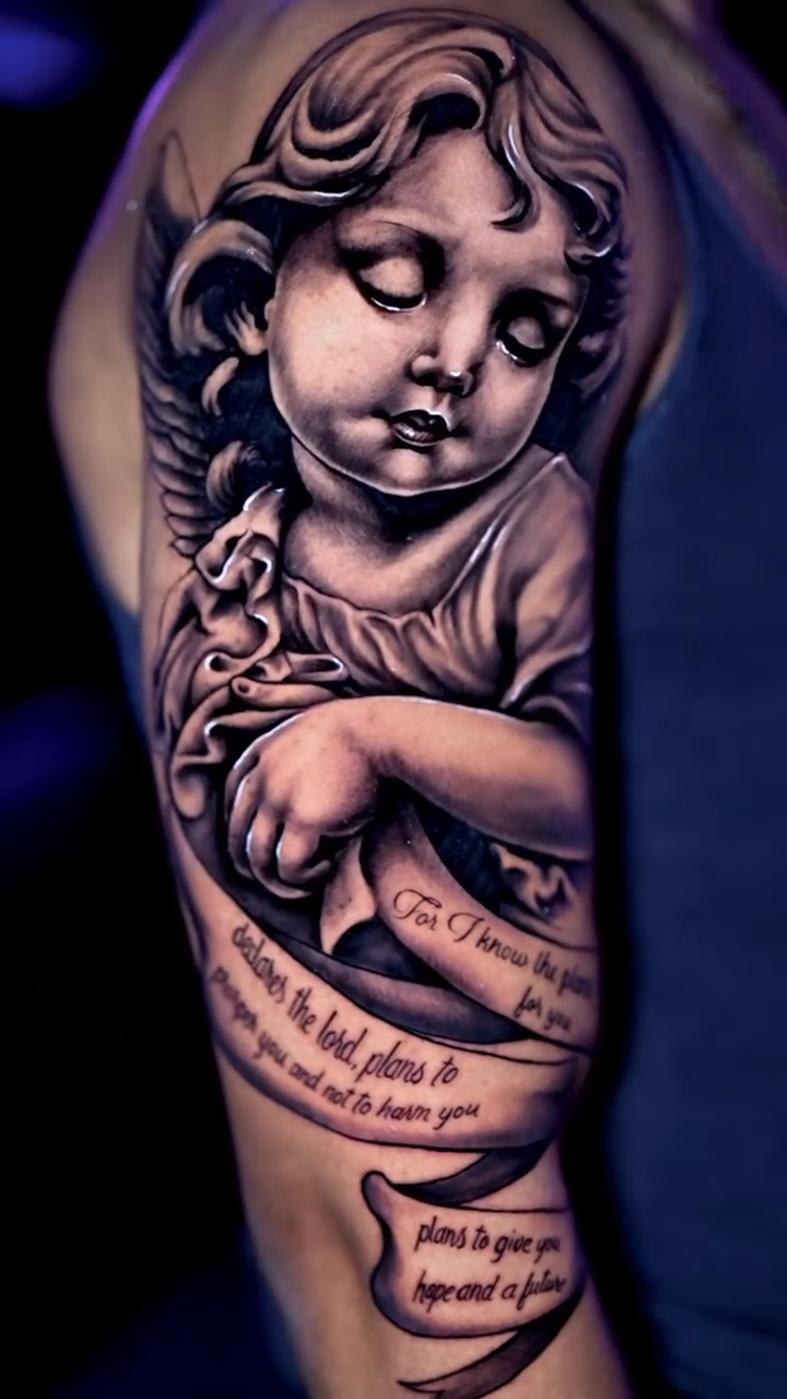 Cherub with banner realism tattoo by Kiefer Fonseca