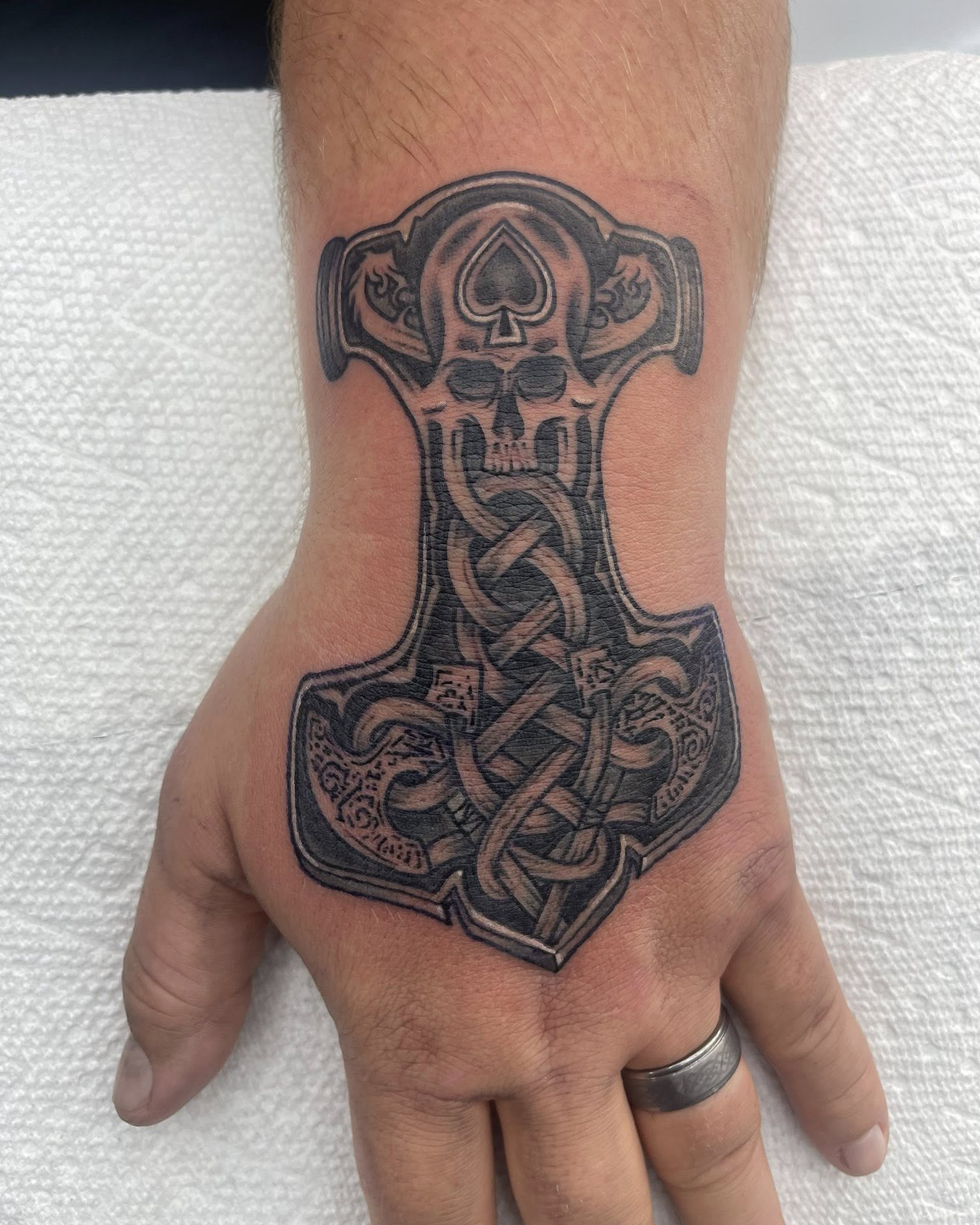 Thor's hammer black and grey tattoo on the hand by Autumn Fulford