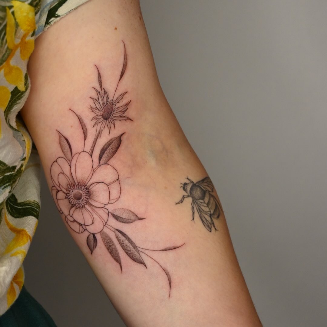 Flowers and bee black and grey tattoo on the forearm by Simba Nguyen