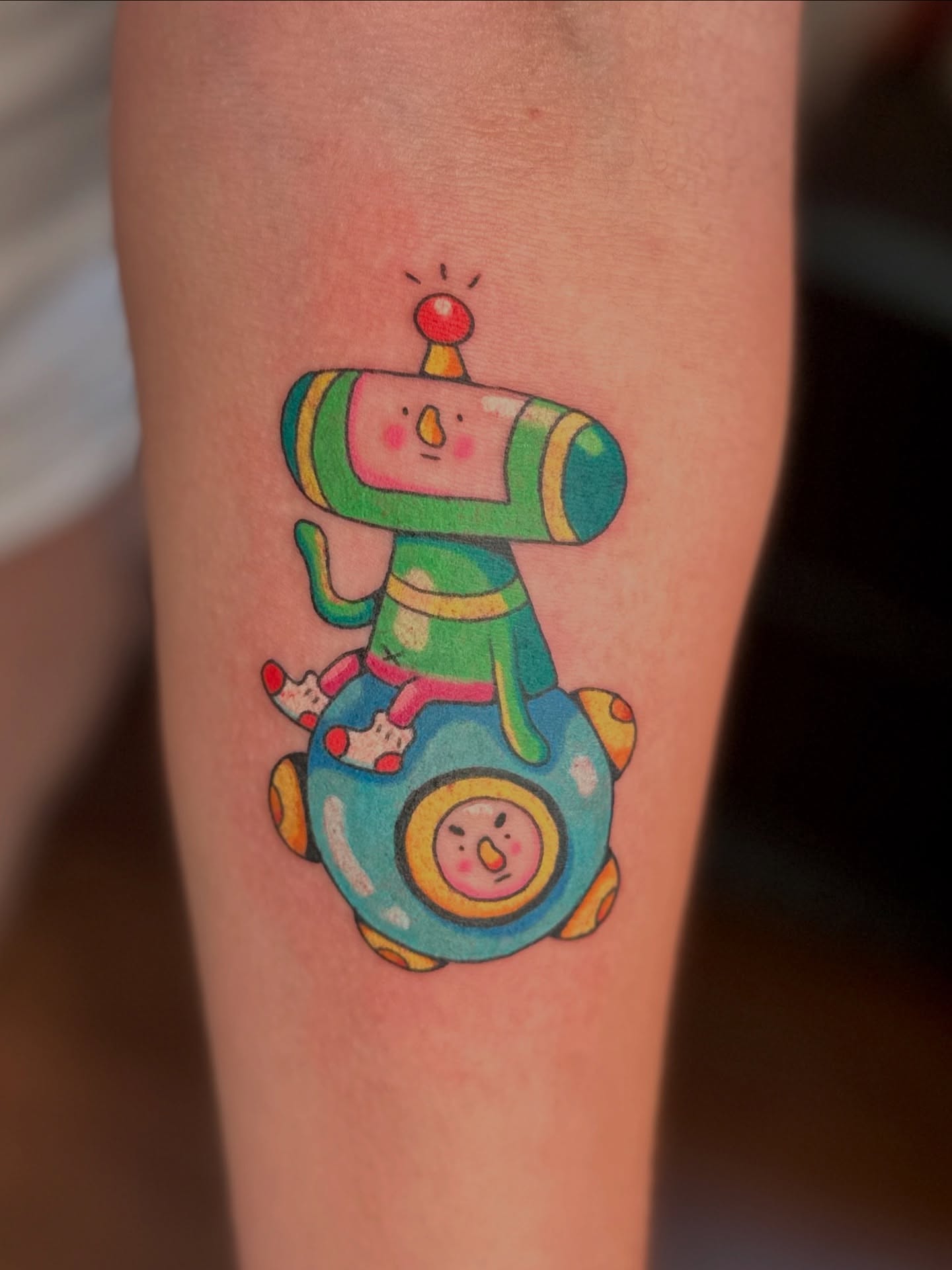 Robot on ball new school tattoo on the forearm by Kellie Burch