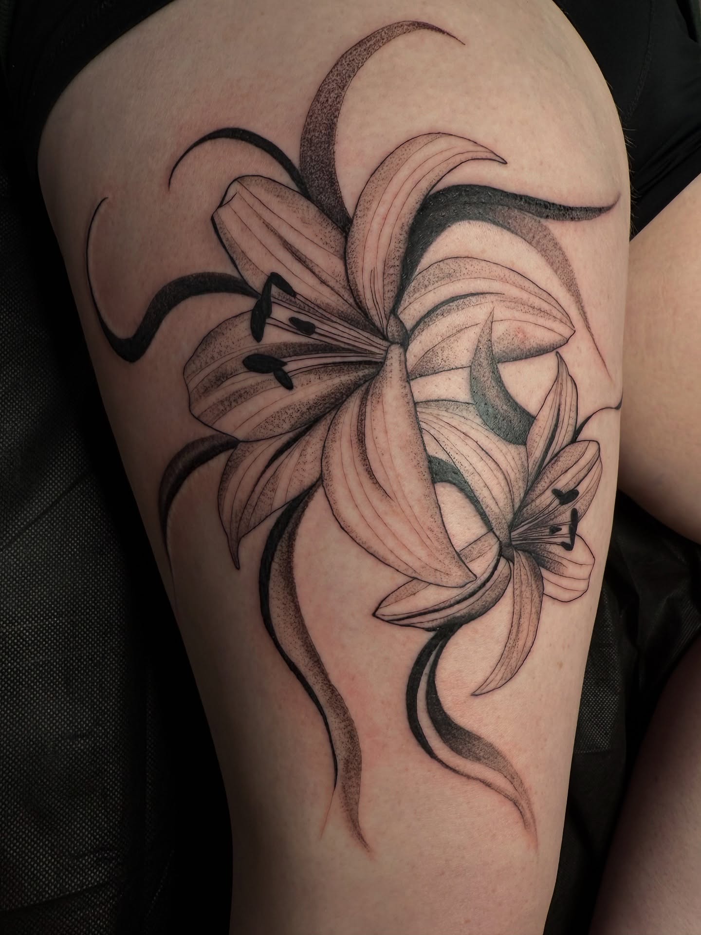 Lily black and grey tattoo on the thigh by ᴍᴀɢɢɪᴇ ✧, Las Vegas, Nevada