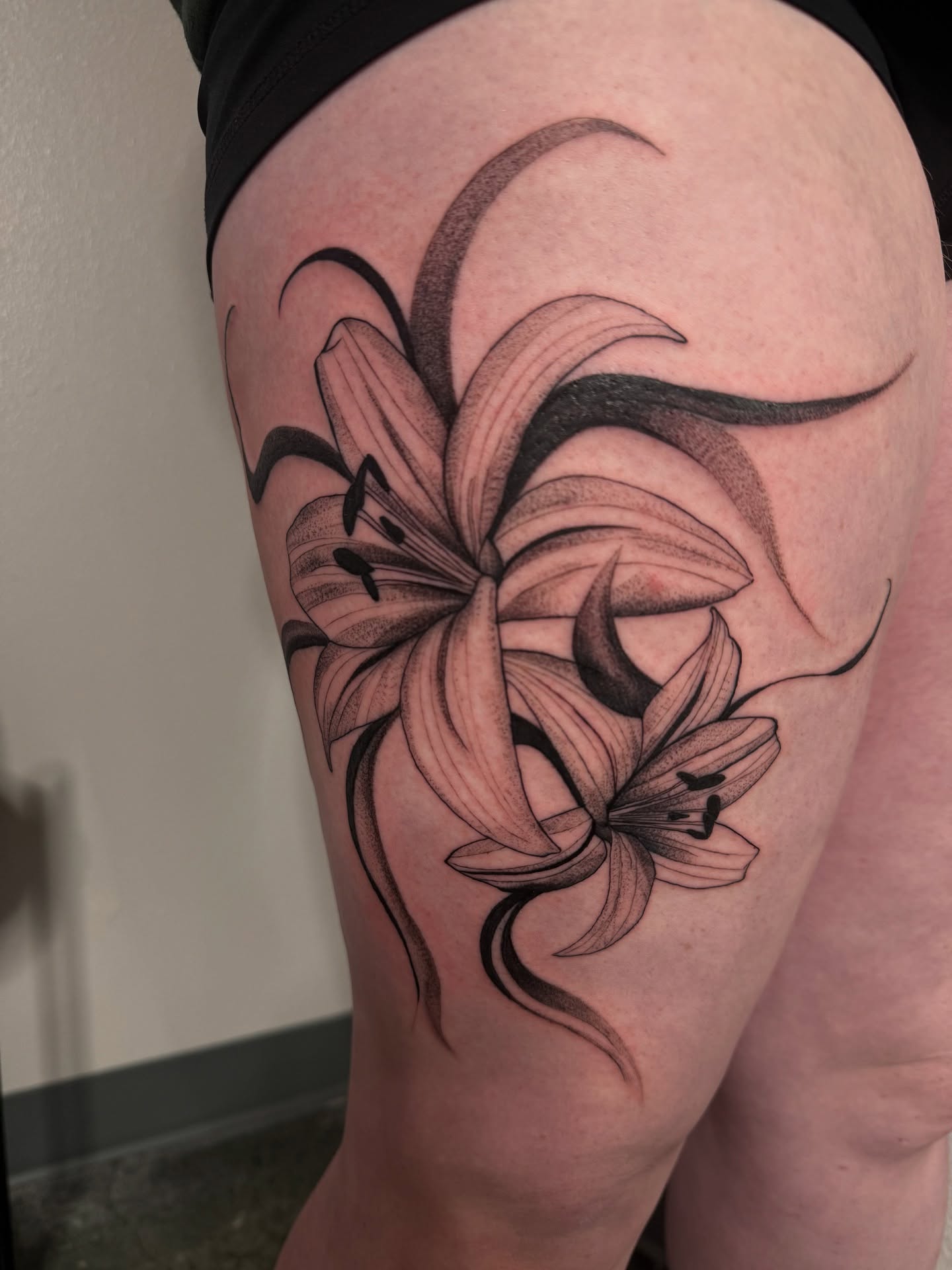 Lilies black and grey tattoo on the thigh by ᴍᴀɢɢɪᴇ ✧, Las Vegas, Nevada