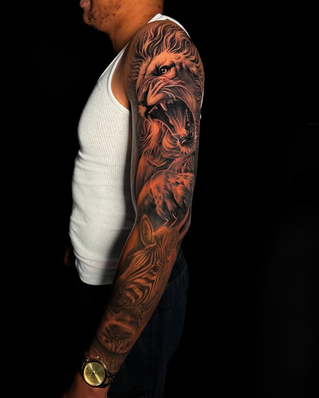 Lion and zebra safari scene Japanese tattoo on the upper arm by Ethan Xu