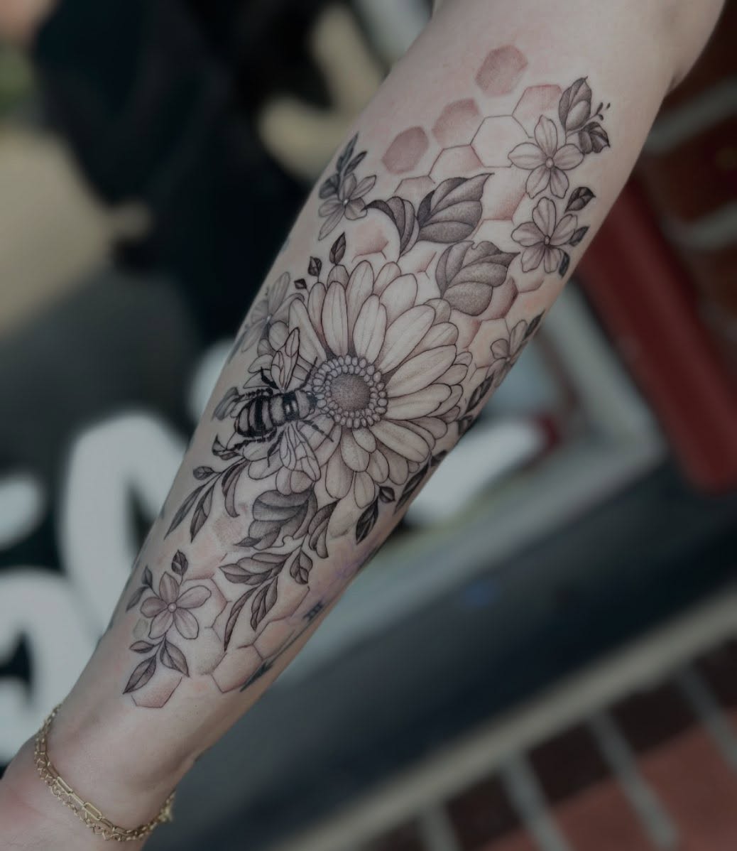 Flower and bee black and grey tattoo on the forearm by Emmy