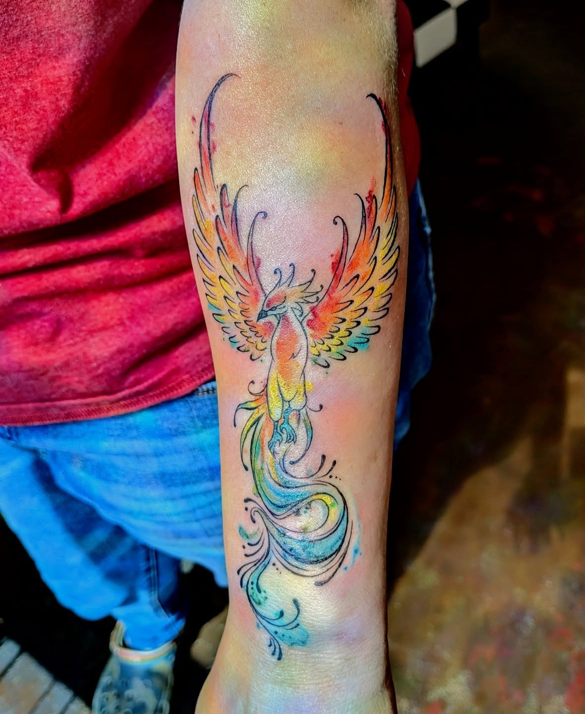 Phoenix watercolor tattoo on the forearm by Shannon