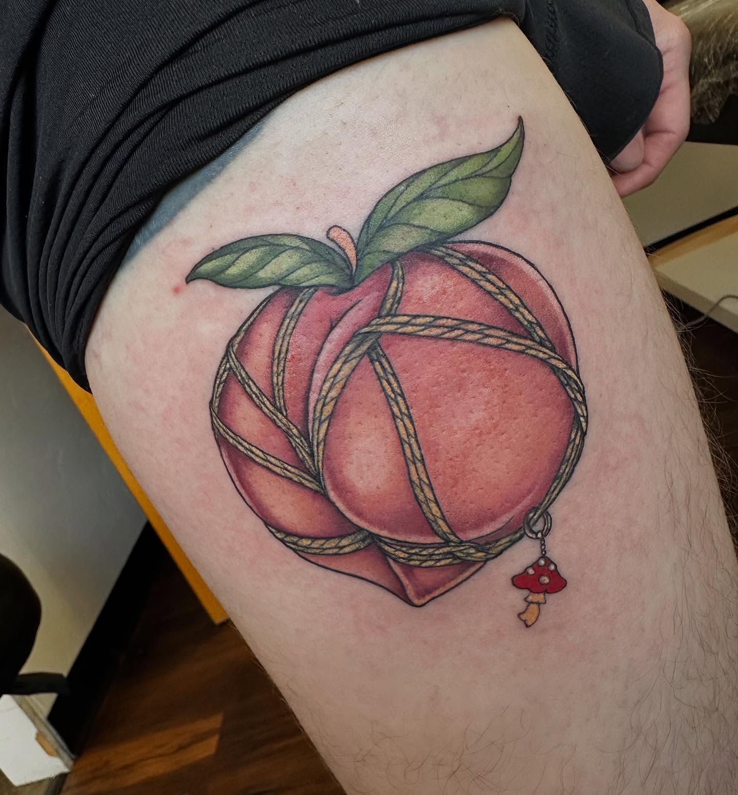 Peach with rope realism tattoo on the thigh by Michele Estes