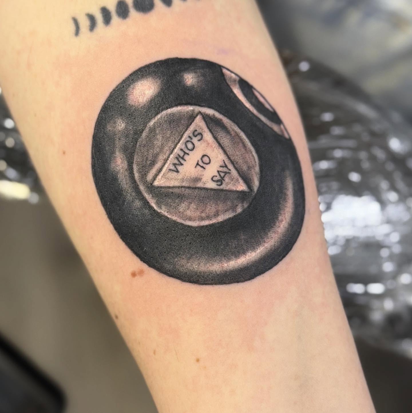 Triangle with text black and grey tattoo on the forearm by Tattoos By Trish