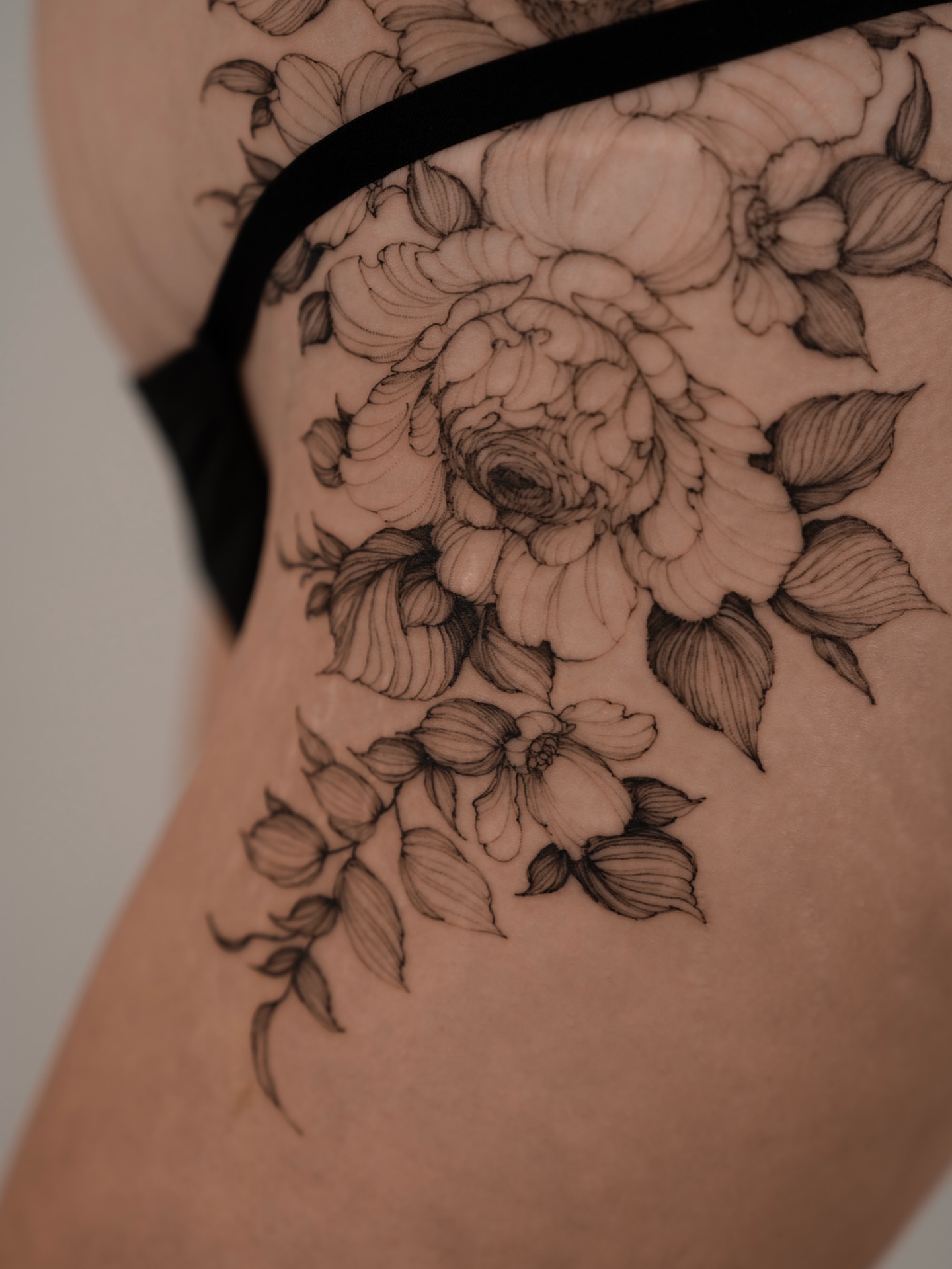 Floral bouquet black and grey tattoo on the thigh by Marek