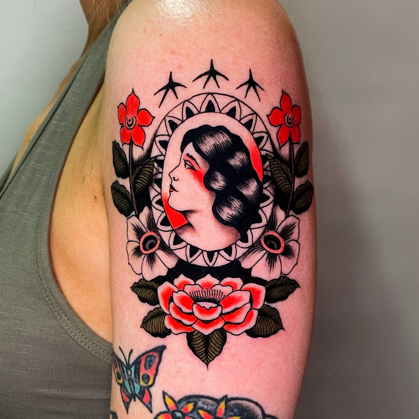 Woman's profile with floral elements American traditional tattoo on the forearm by Niko Mulhearn