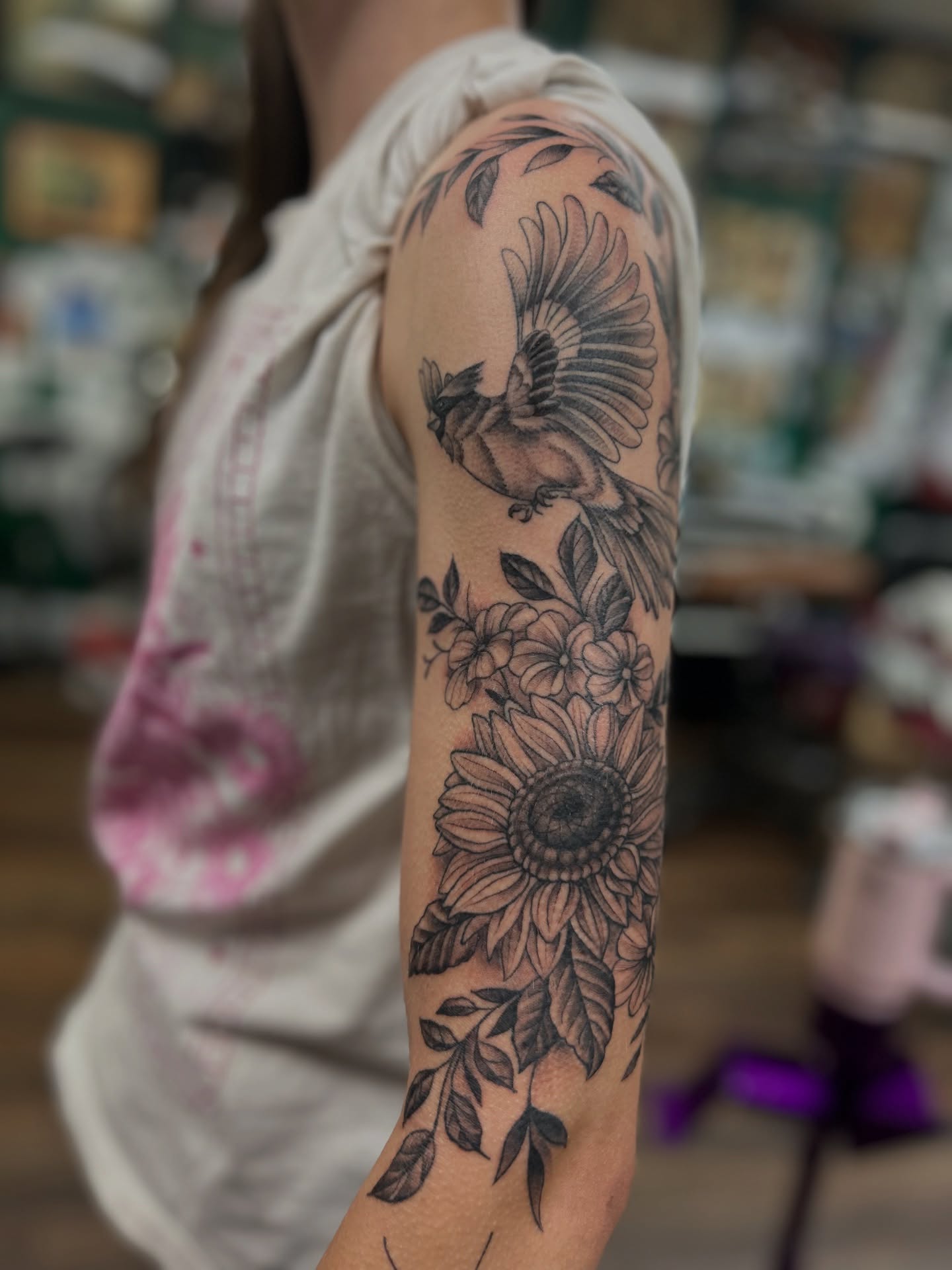 Sunflower and bird black and grey tattoo on the forearm by Patricia Cunningham