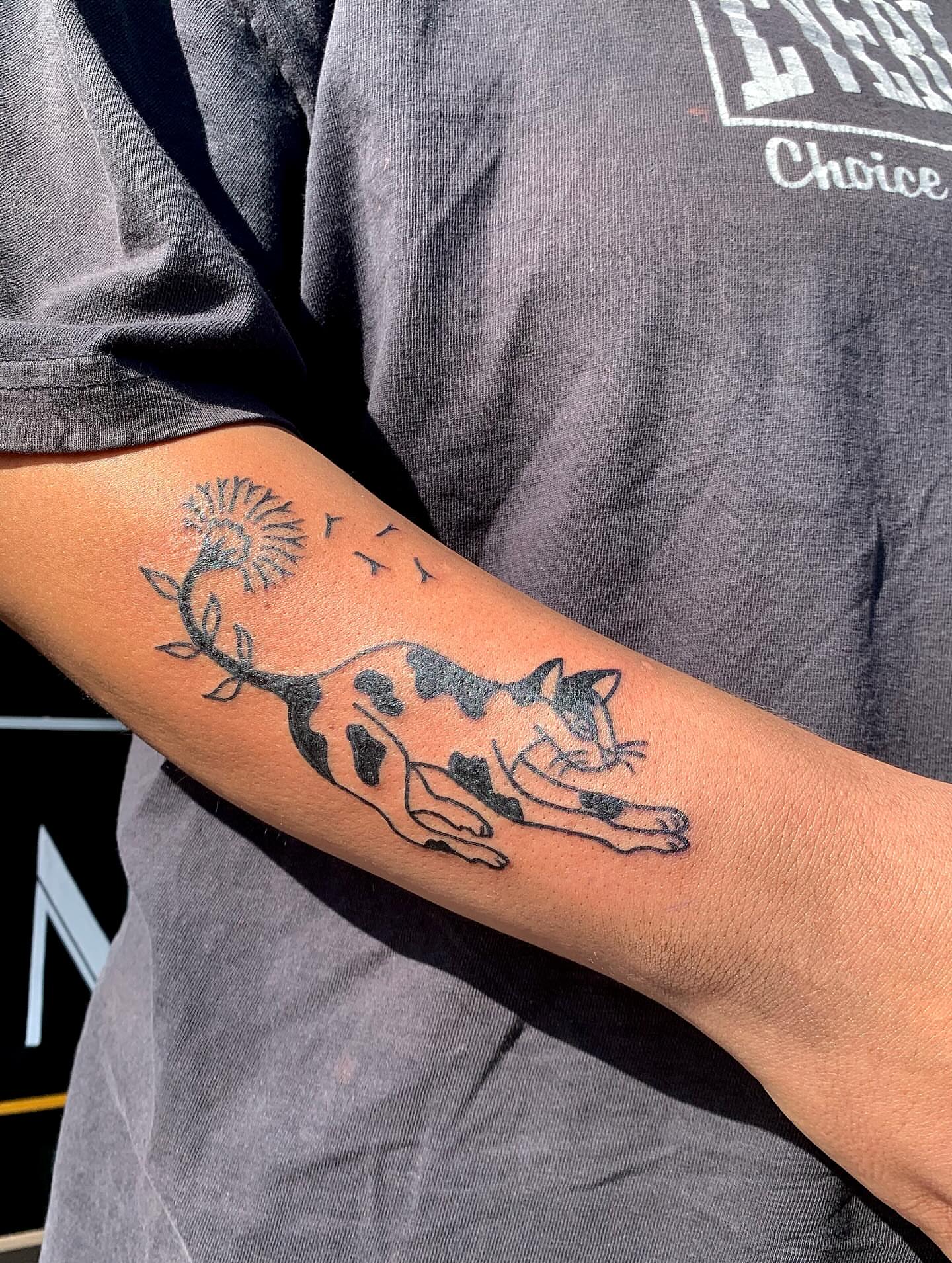 Cat and dandelion black and grey tattoo on the forearm by ellie