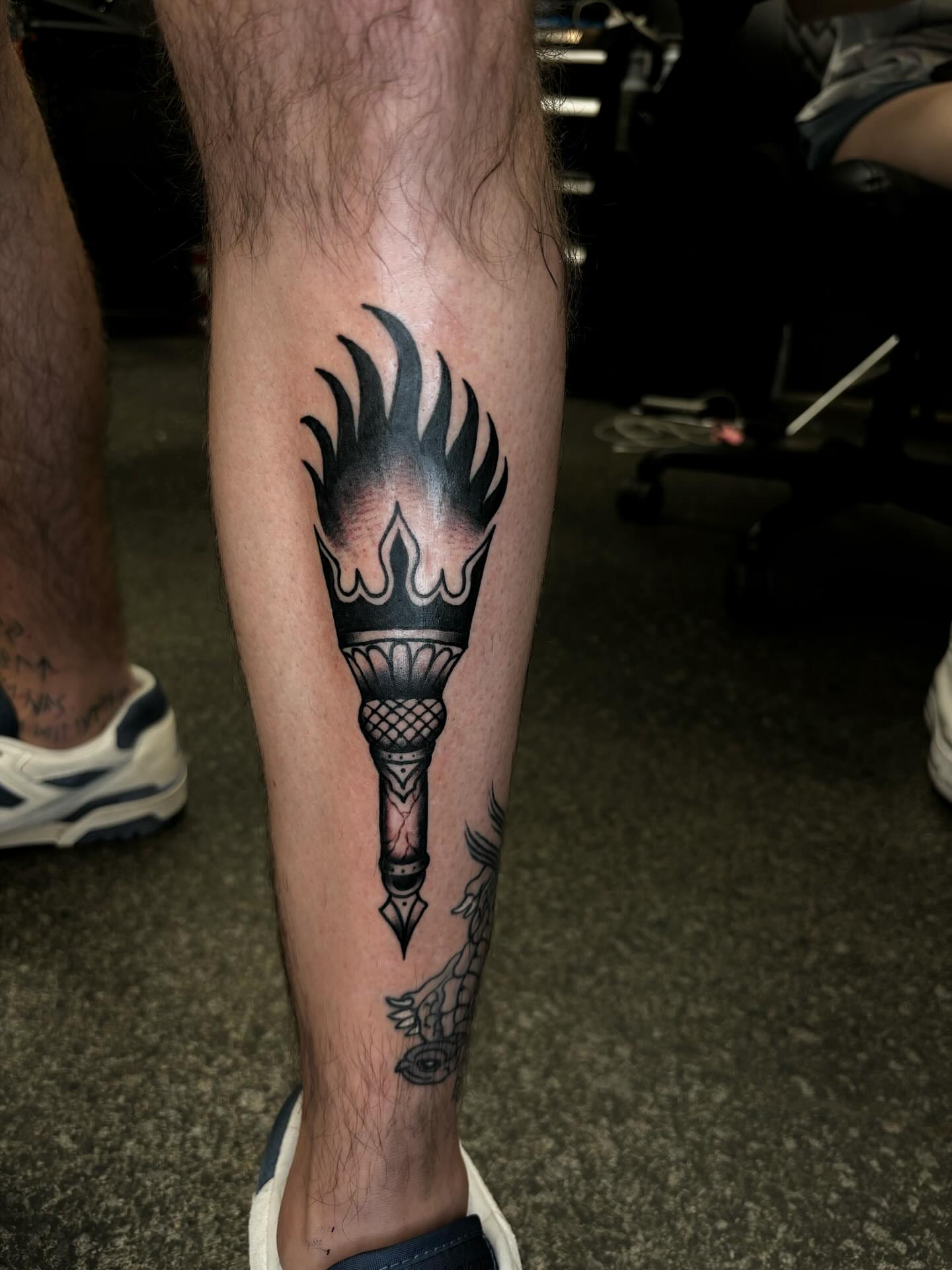 Torch black and grey tattoo on the calf by Brett Ferguson
