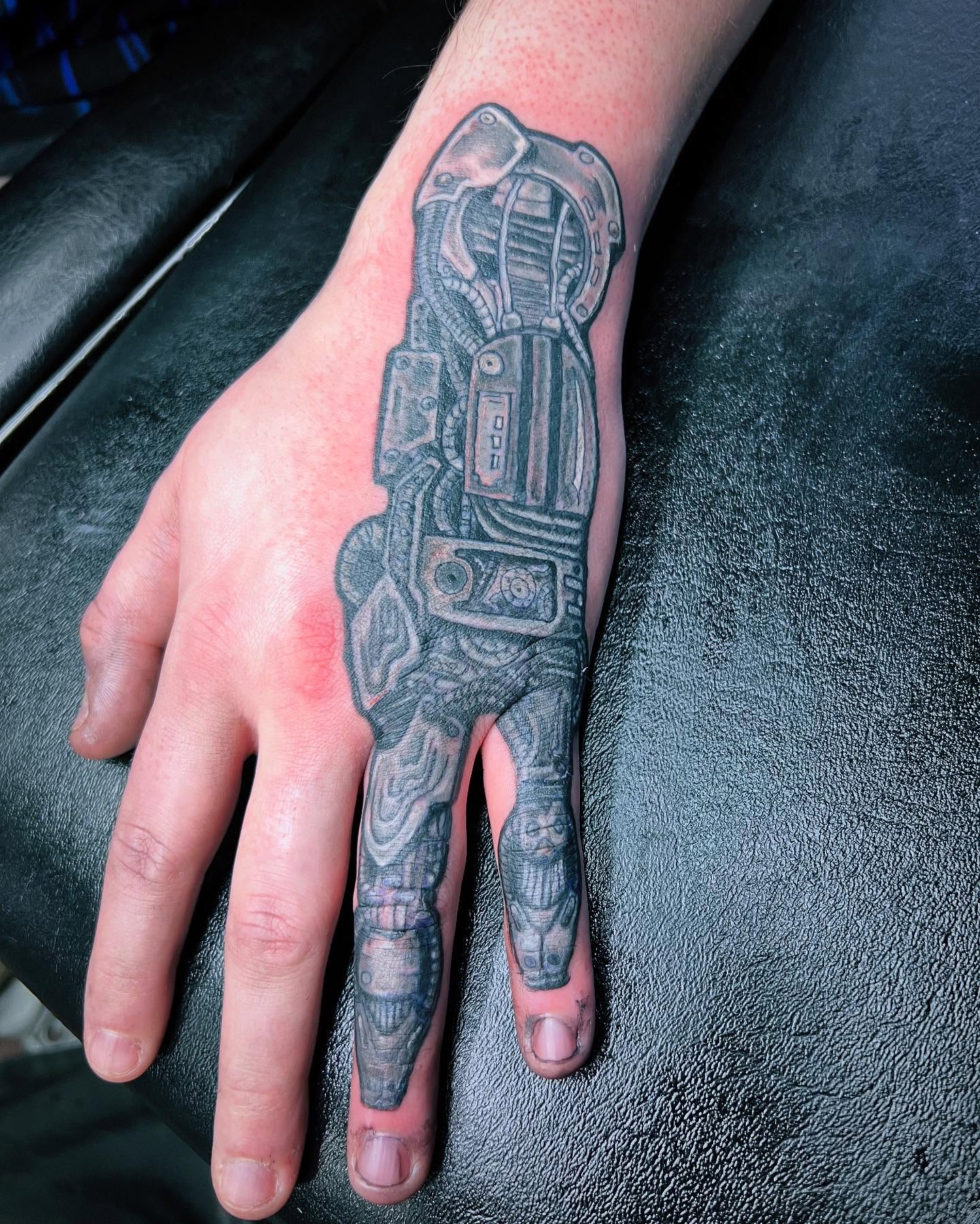 Mechanical suit black and grey tattoo on the hand by @lady_raven_tattoo