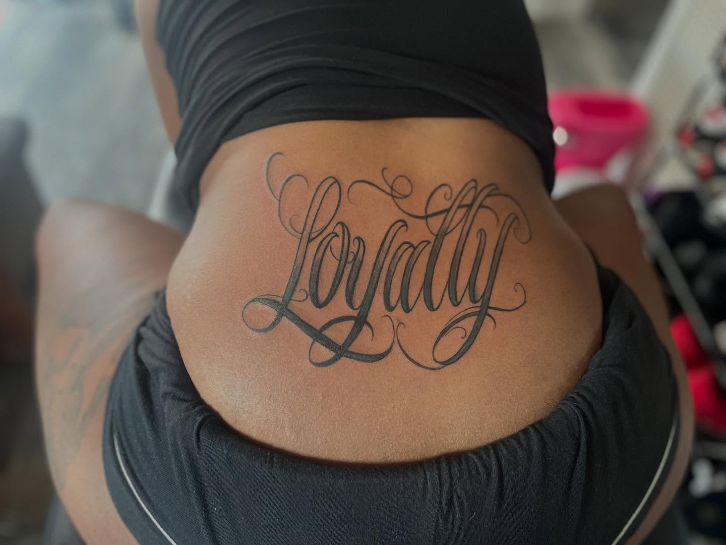Loyalty lettering script tattoo on the torso by Bris