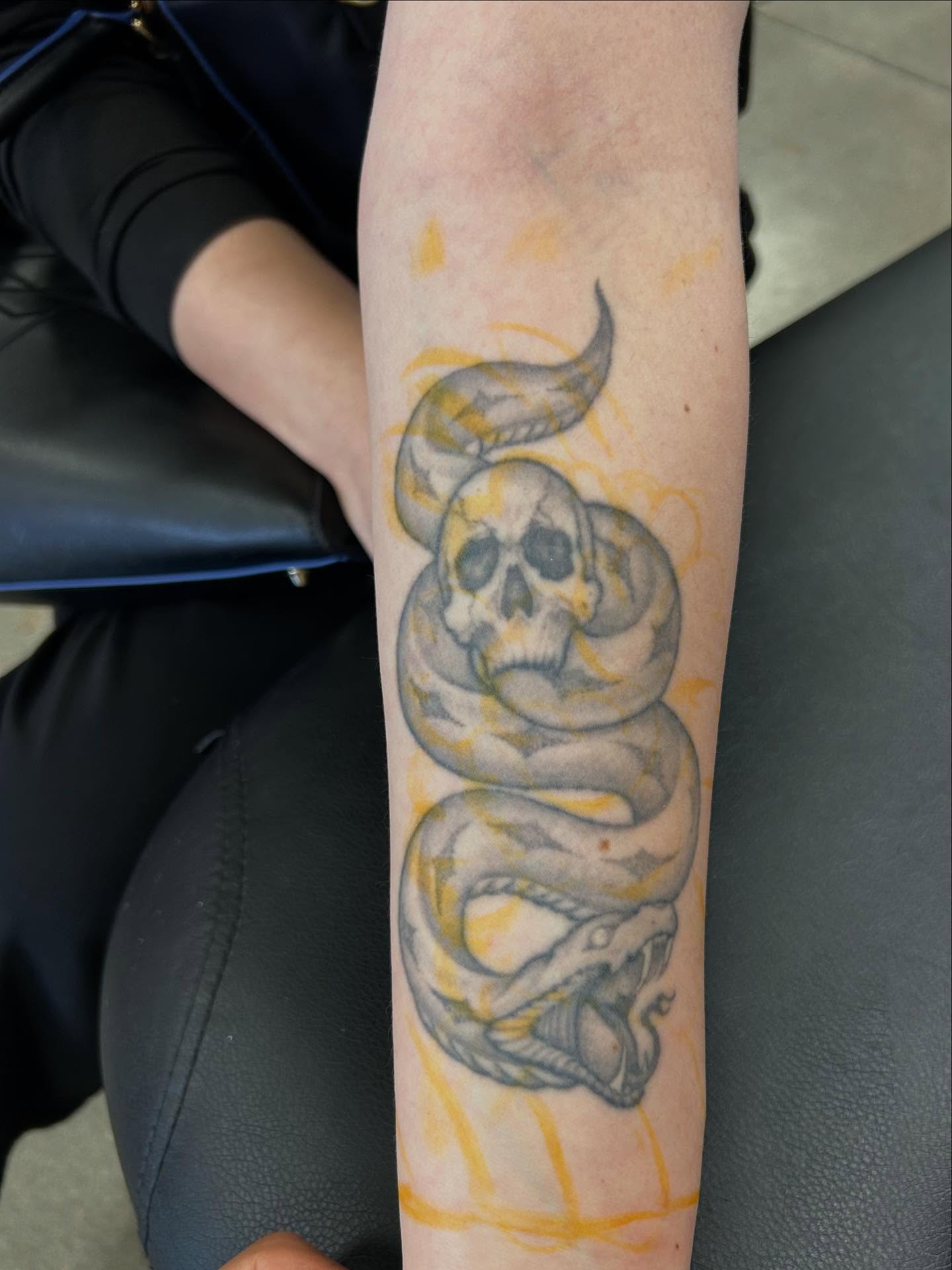 Snake and skull black and grey tattoo on the forearm by Shawn Feng