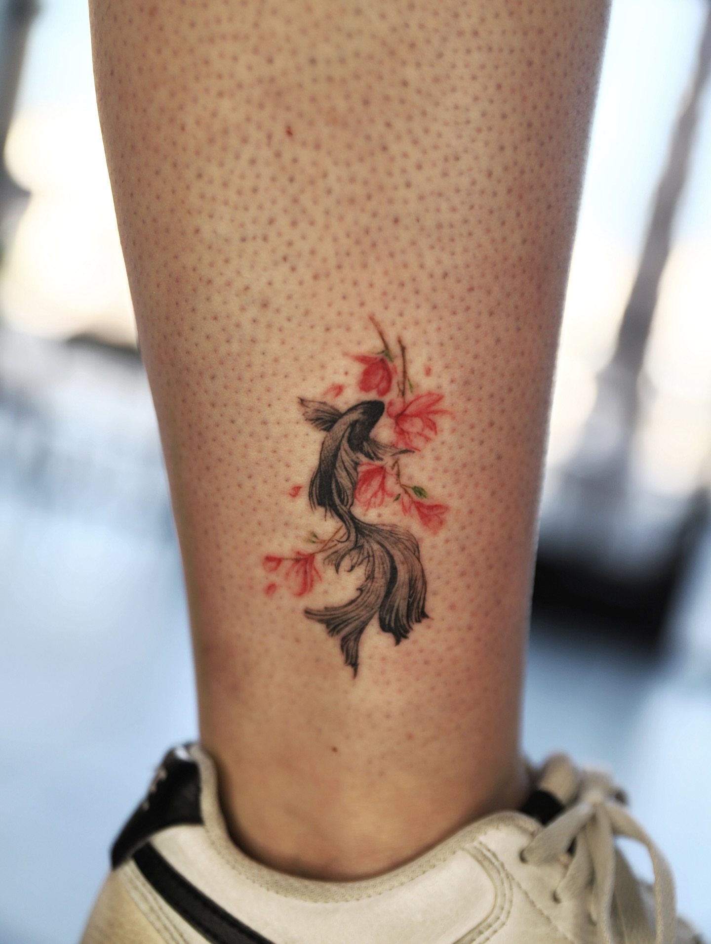 Goldfish and flowers dotwork tattoo on the calf by Las Vegas tattoo