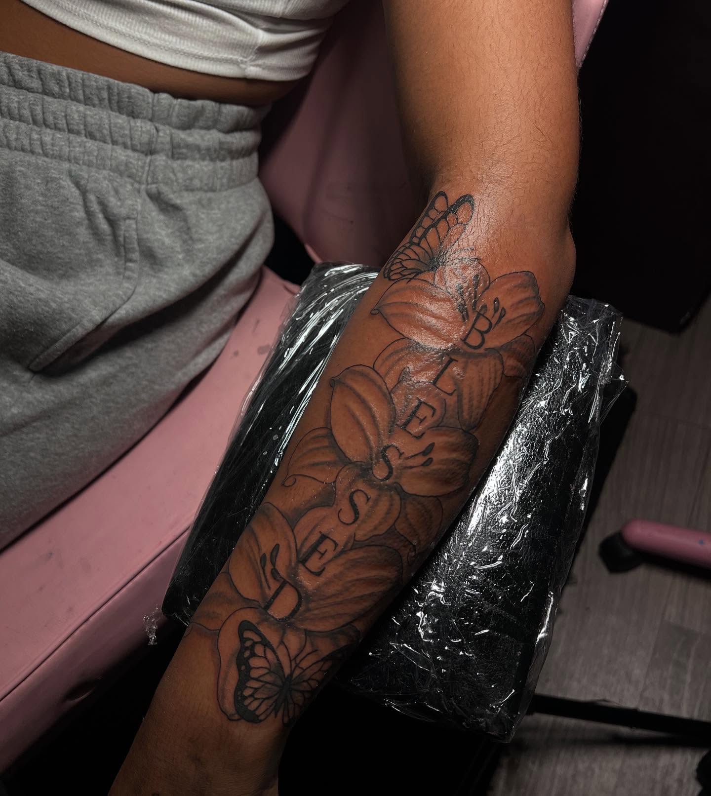 Floral design black and grey tattoo on the forearm by Tatted By Layy