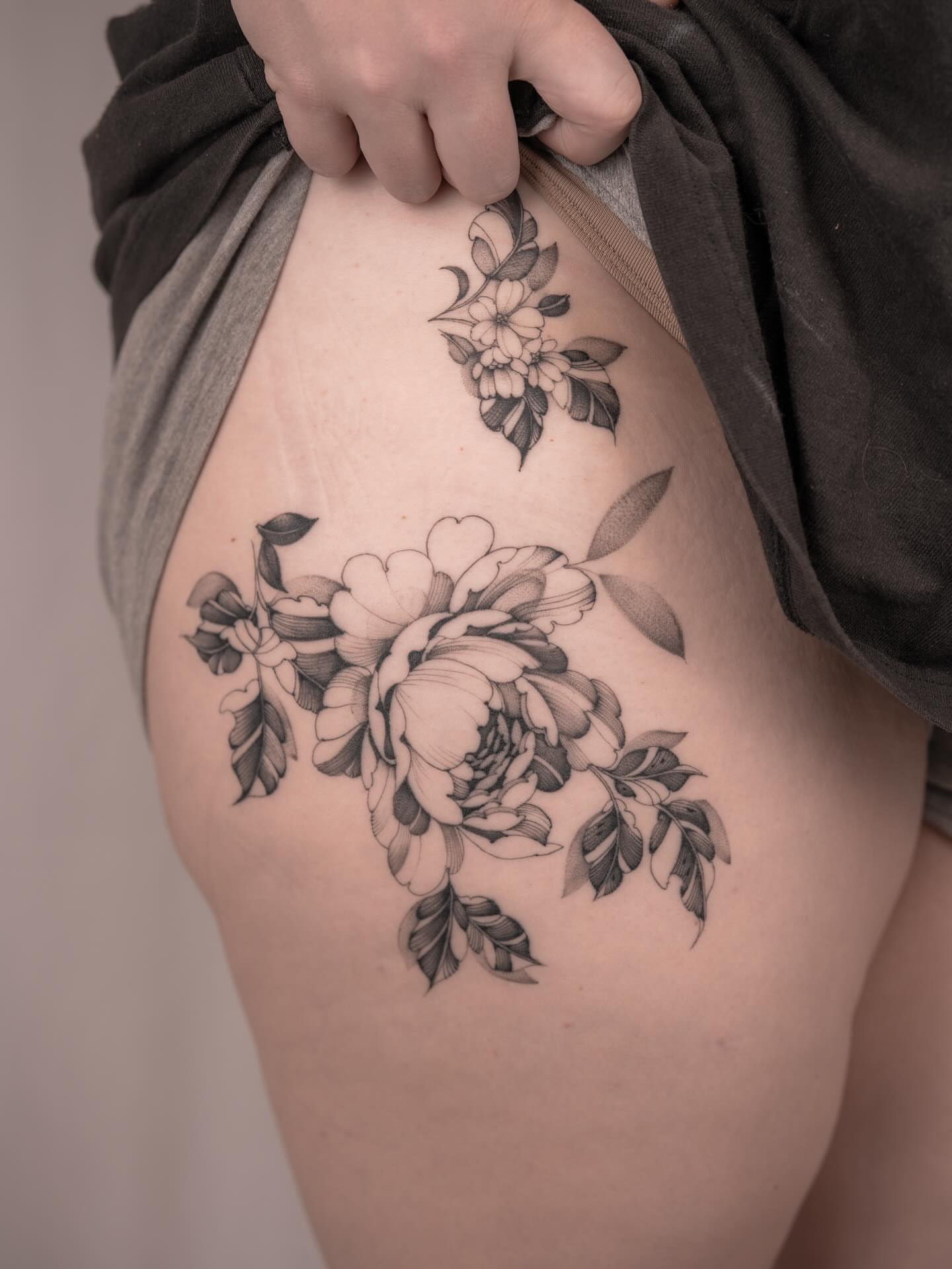 Floral bouquet black and grey tattoo on the thigh by Leo Gao
