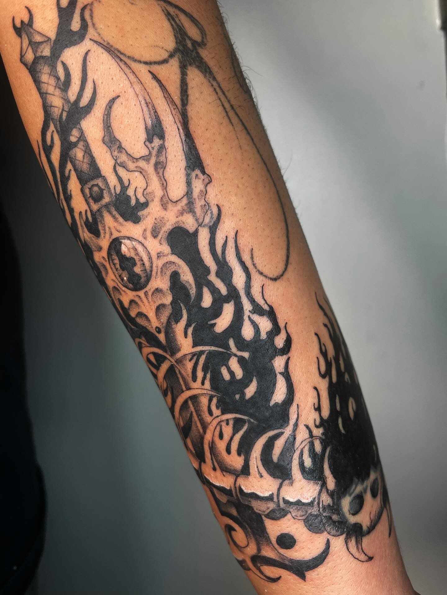 Flame and skull black and grey tattoo on the forearm by Vash