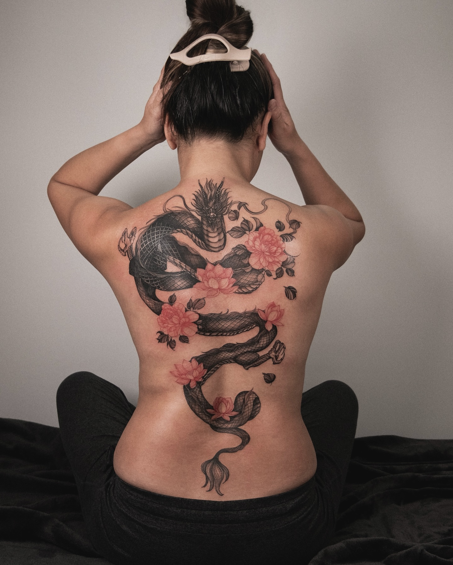 Dragon and flowers realism tattoo on the back by Wong Lee